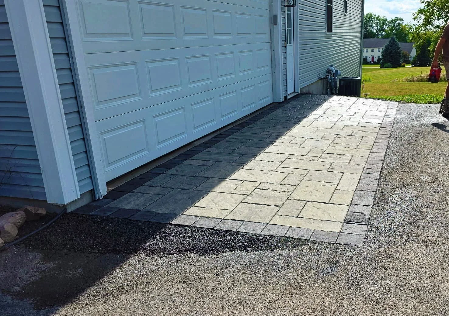 Completed concrete driveway repair spanning the entrance of a residential garage in Central New York.