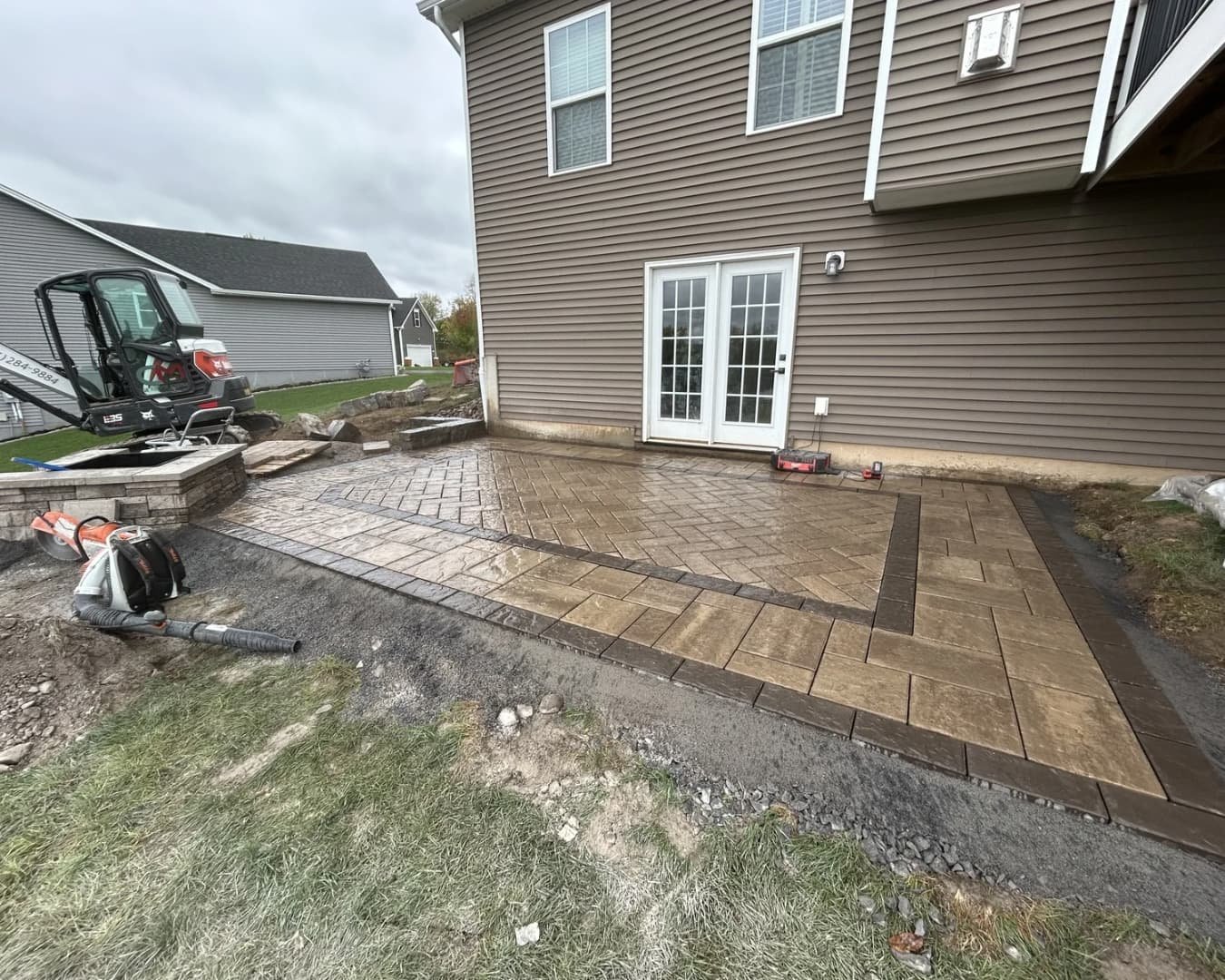 Newly graded backyard area prepared for hardscape installation at a Central New York home.