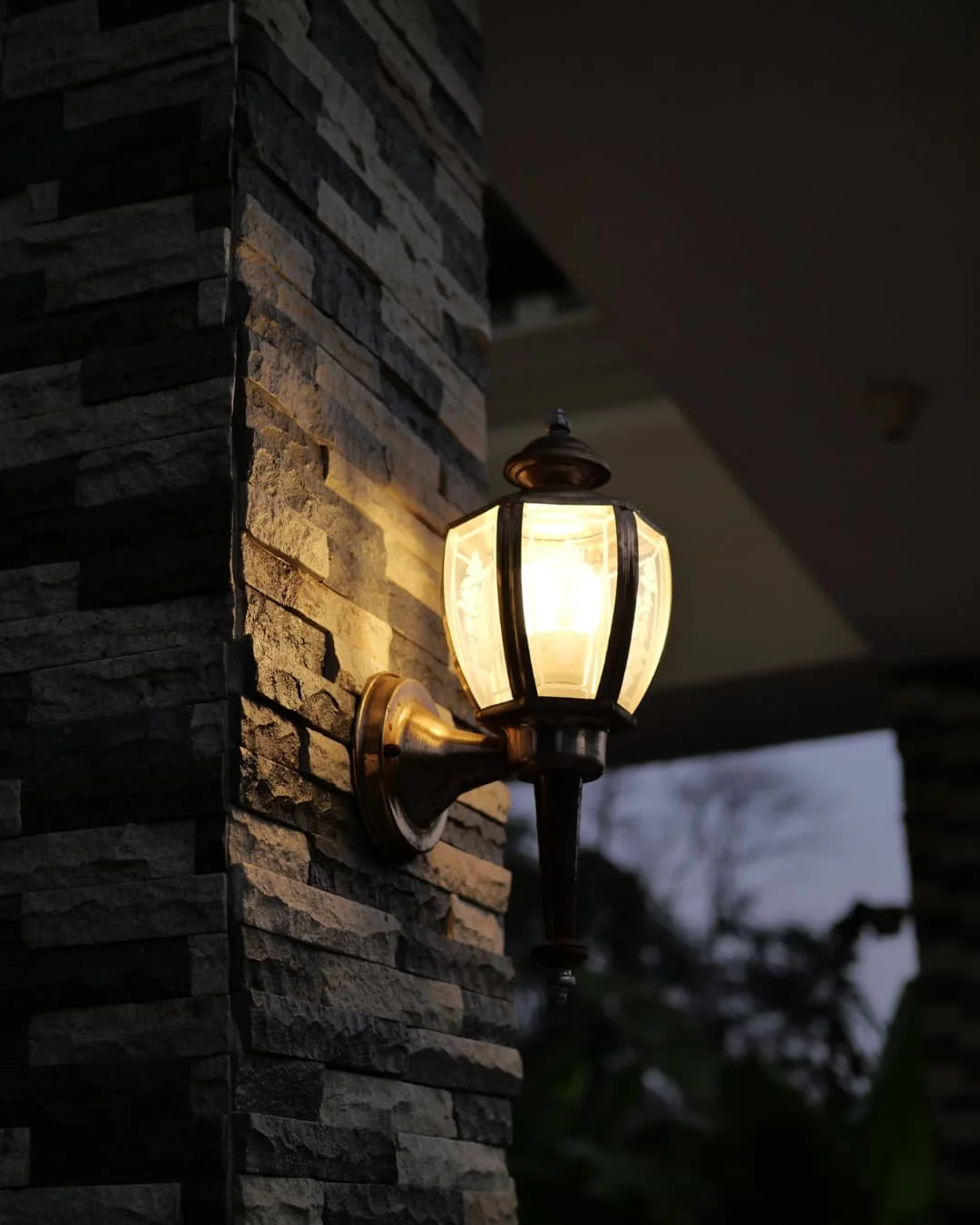 Outdoor lighting inspiration with a wall-mounted lantern illuminating a stone exterior surface.