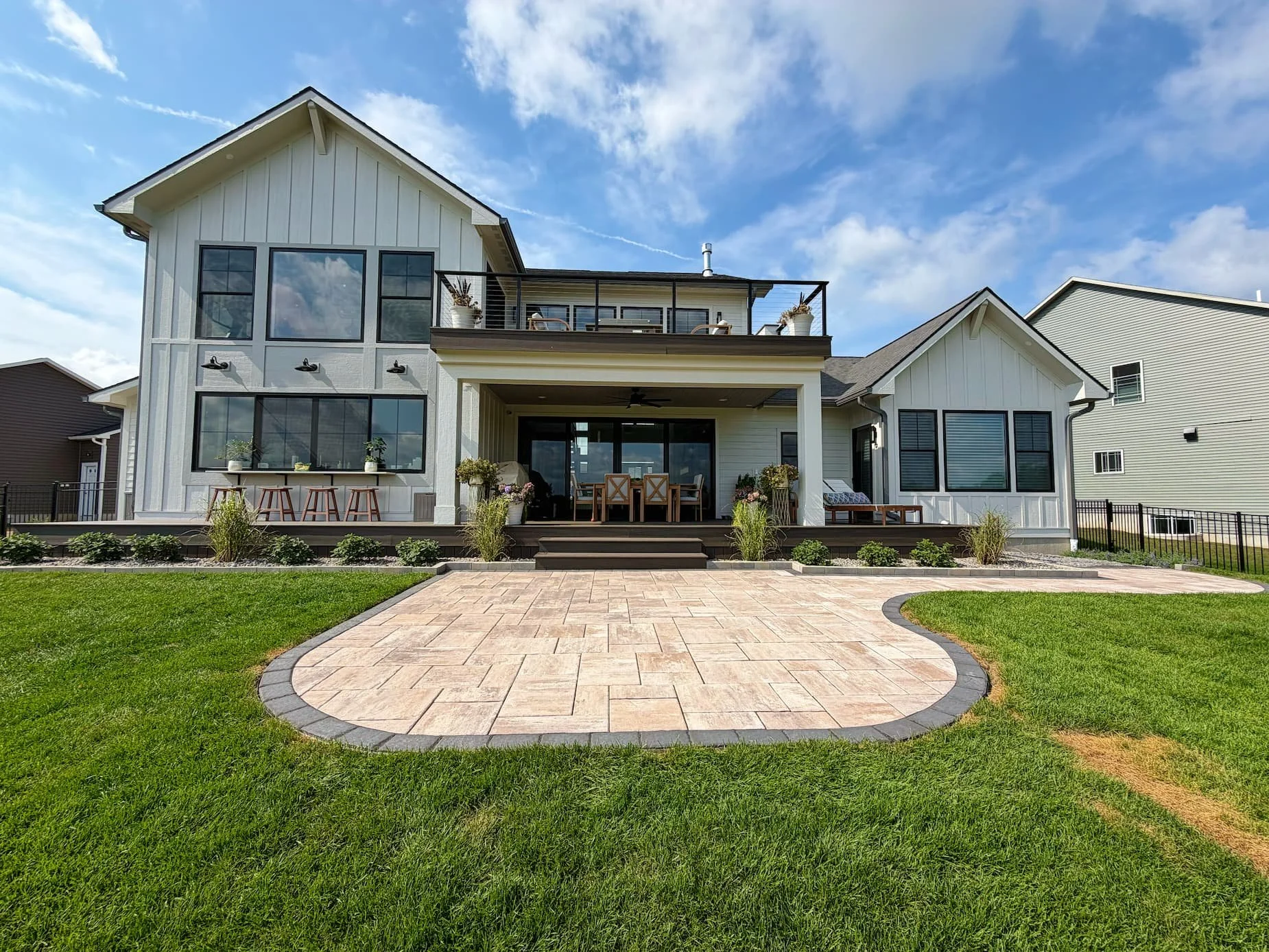 Large custom paver patio extending from a covered outdoor living area in Central NY