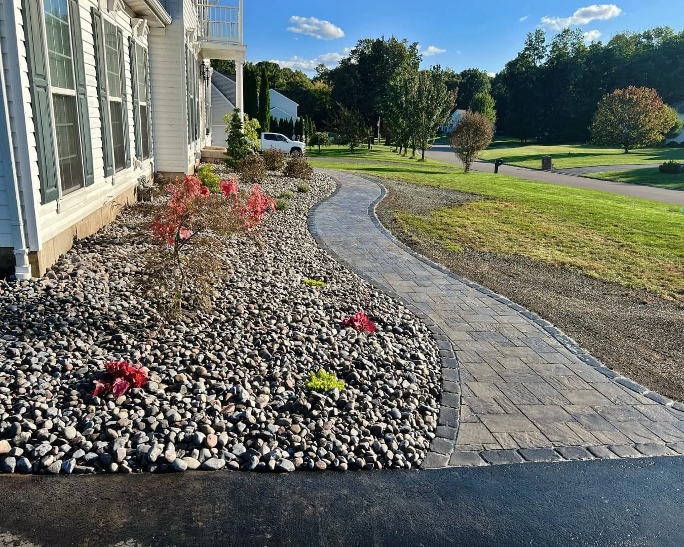 Curved front walkway and planting bed completed by Pines and Pavers in Baldwinsville, New York.