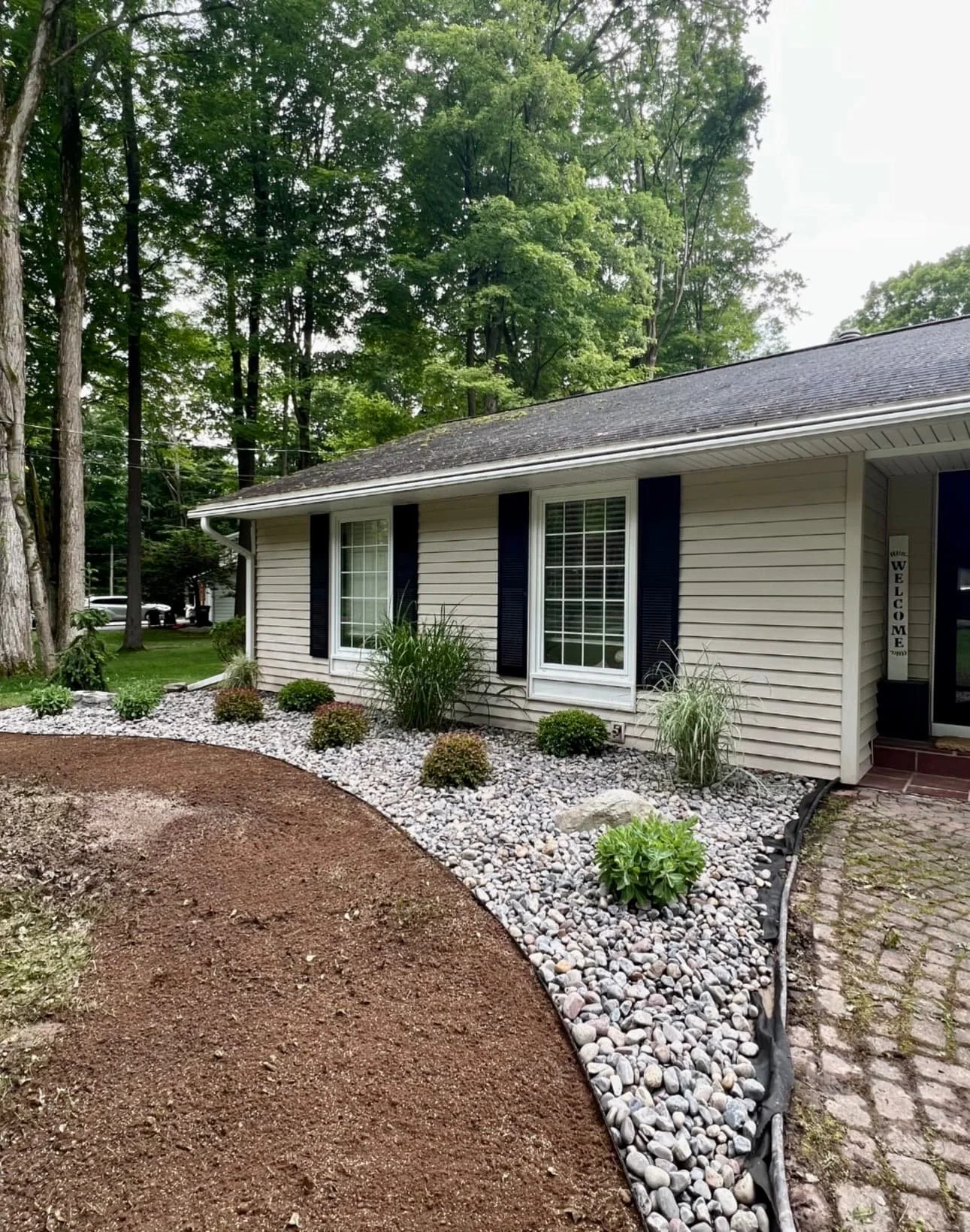 Front home landscaping overview at a Cazenovia, NY property with refreshed beds and a clean residential setting.