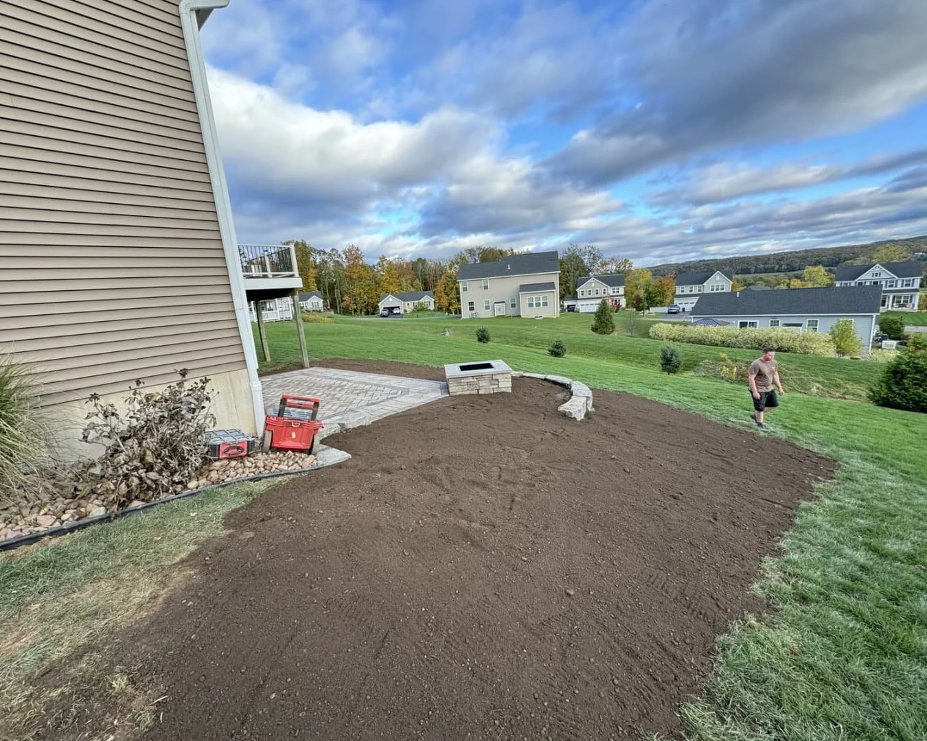 Paver step and patio installation underway beside a deck at an Upstate New York home.