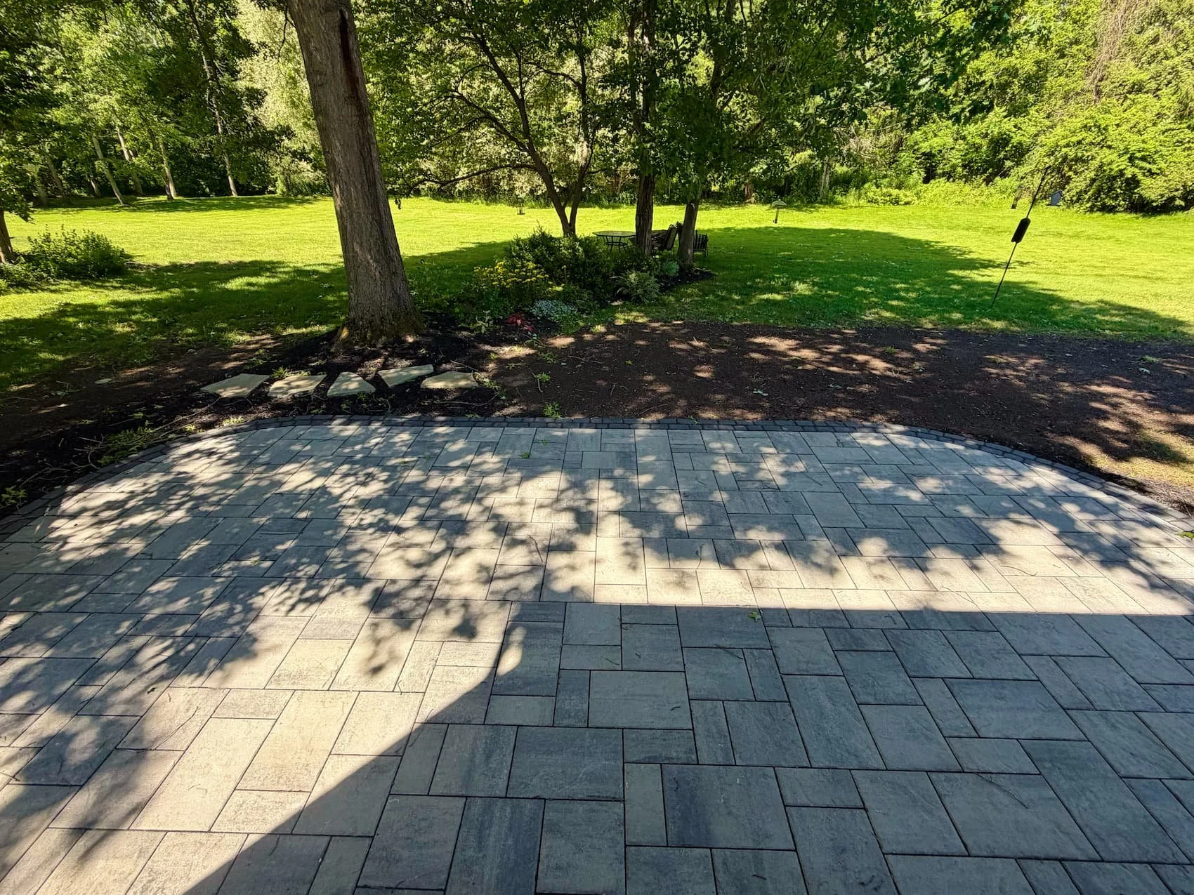 Custom paver patio installation creating a finished backyard outdoor living space in Central New York.