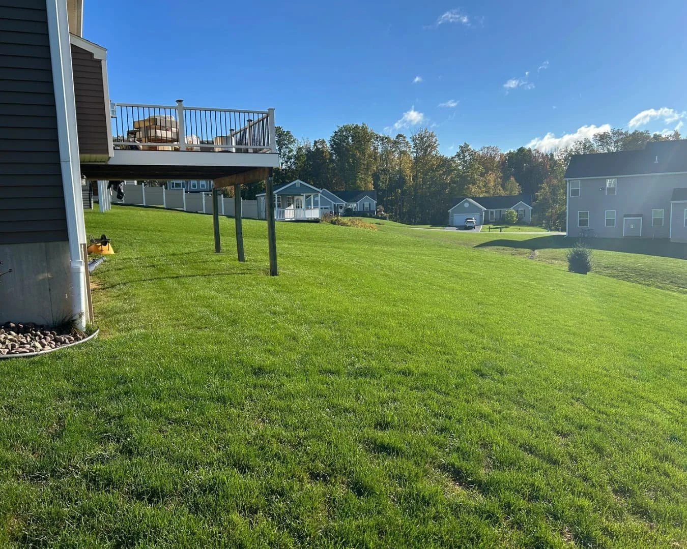 Open backyard lawn overview completed by Pines and Pavers in Lysander, New York.