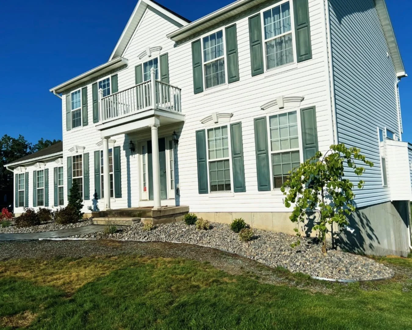Side yard grading and lawn area at a Central New York property following a residential hardscape installation.