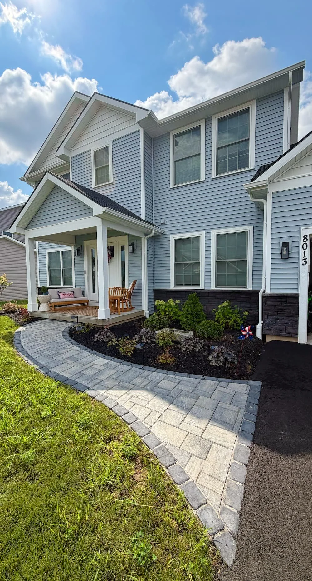 Finished front walkway and landscaping installation beside a Central New York home.