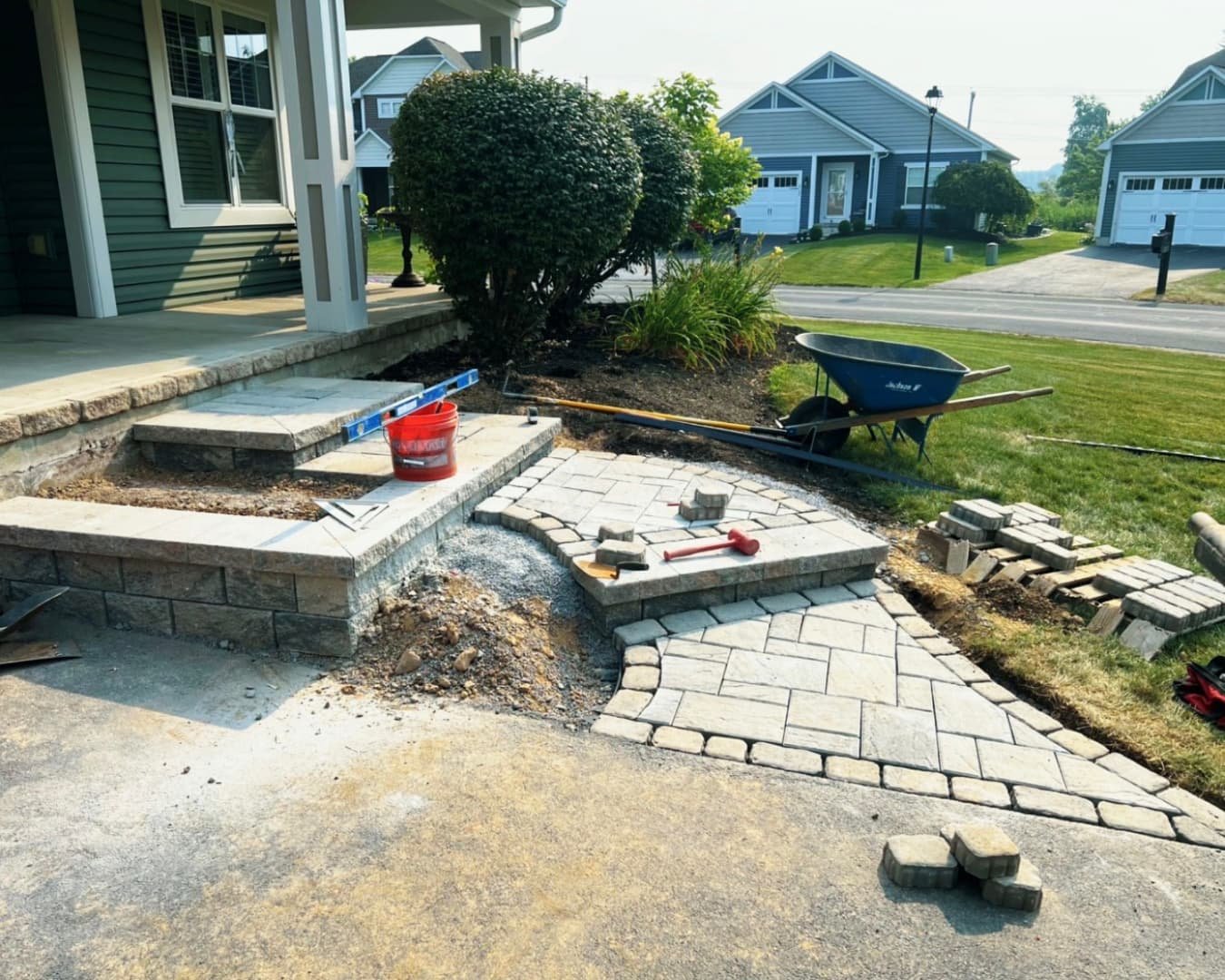 Curved front steps and entry landing at a Central New York home with a clean hardscape layout in progress.