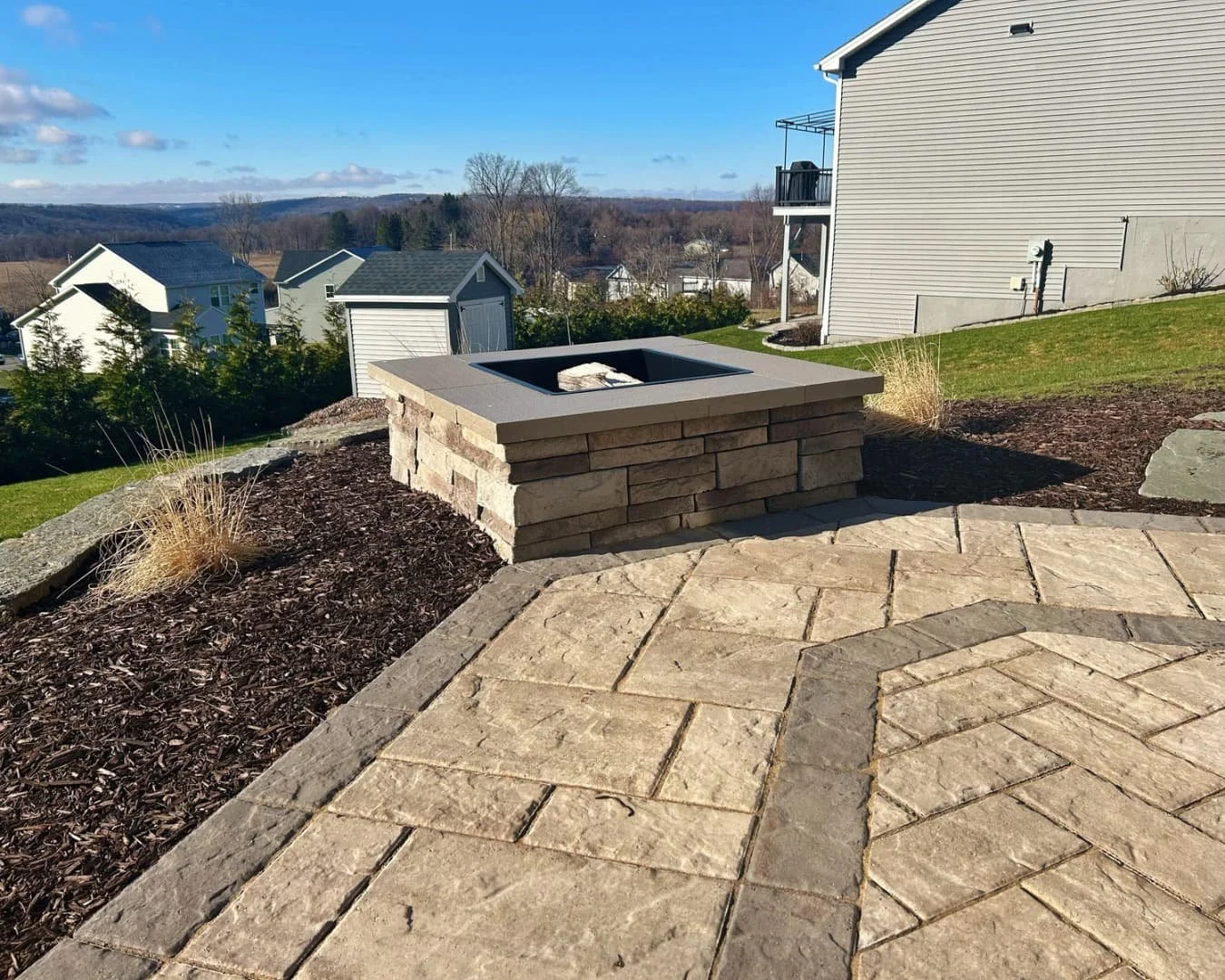 Patio step wall and border detail completed by Pines and Pavers in Lysander, New York.
