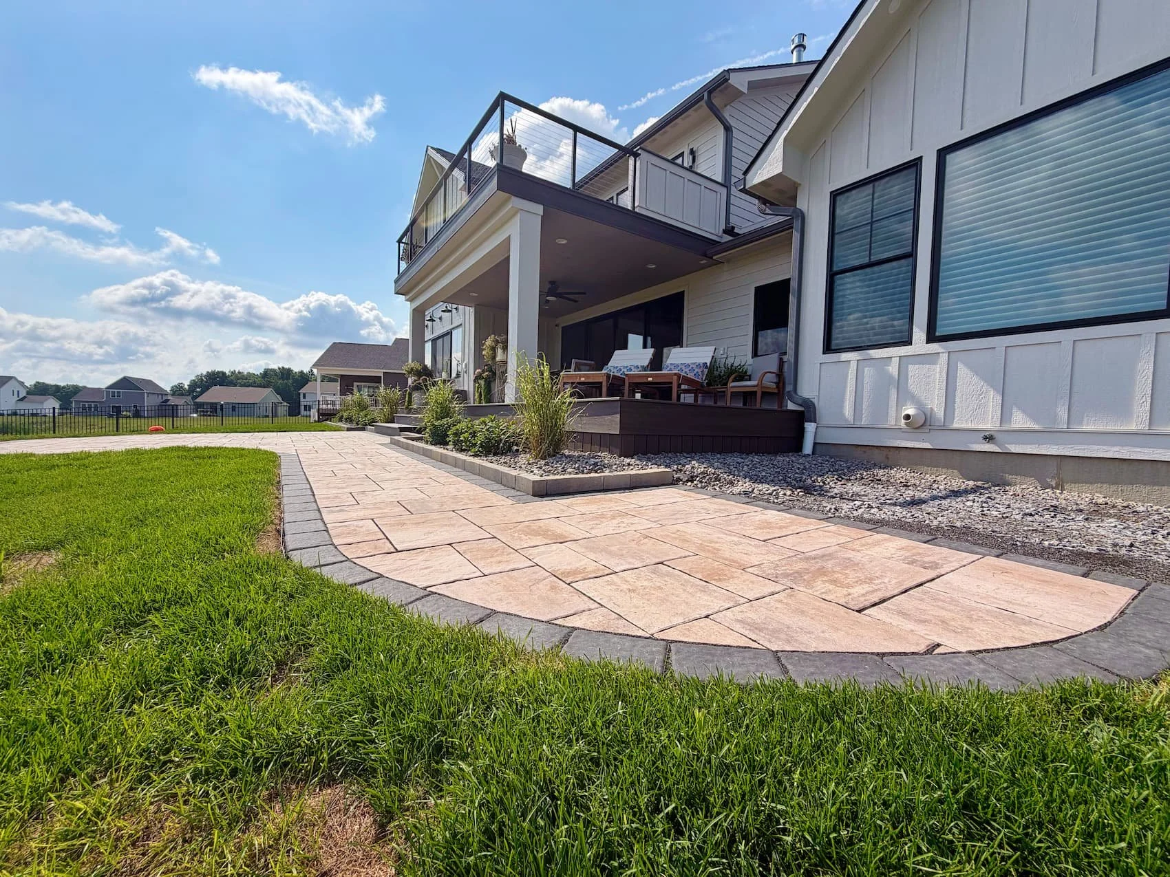 Custom paver patio with curved edge and surrounding lawn in Central NY
