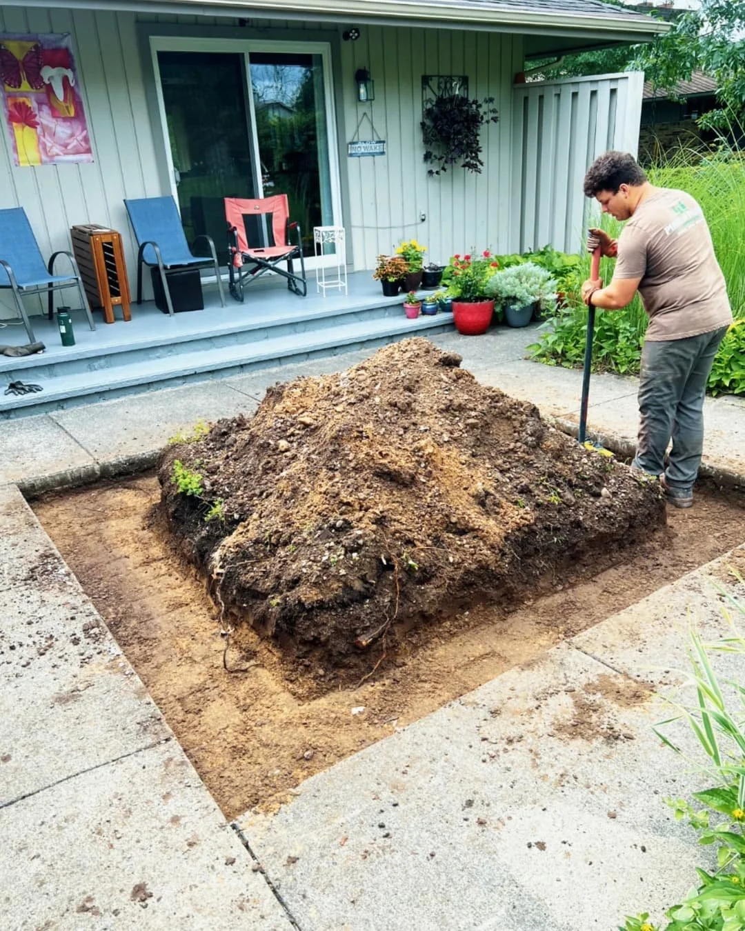  Raised planter installation at a Skaneateles, NY home with fresh soil prep and a custom outdoor feature in progress.