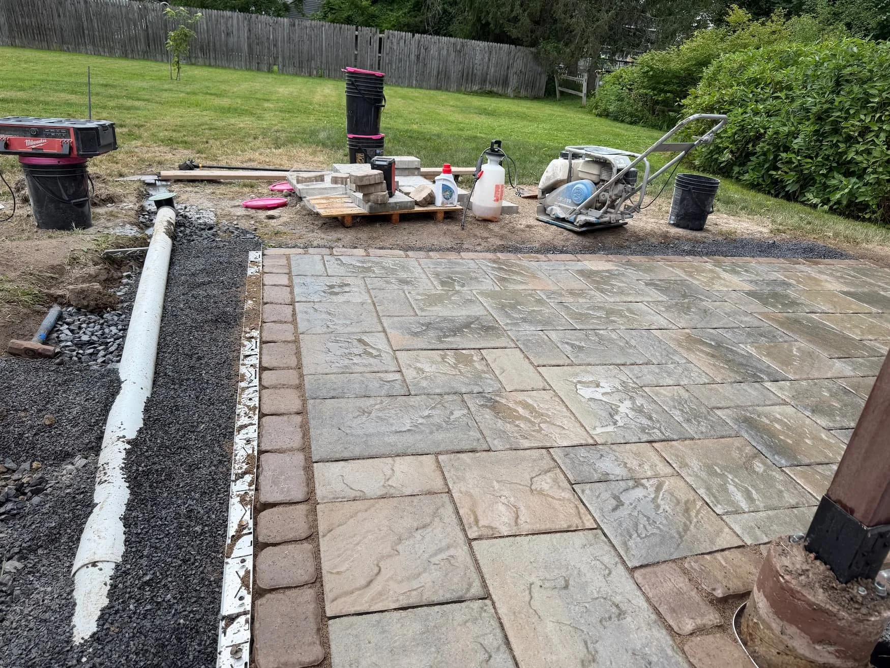Existing backyard lawn beside a raised deck before landscaping improvements in Central New York.