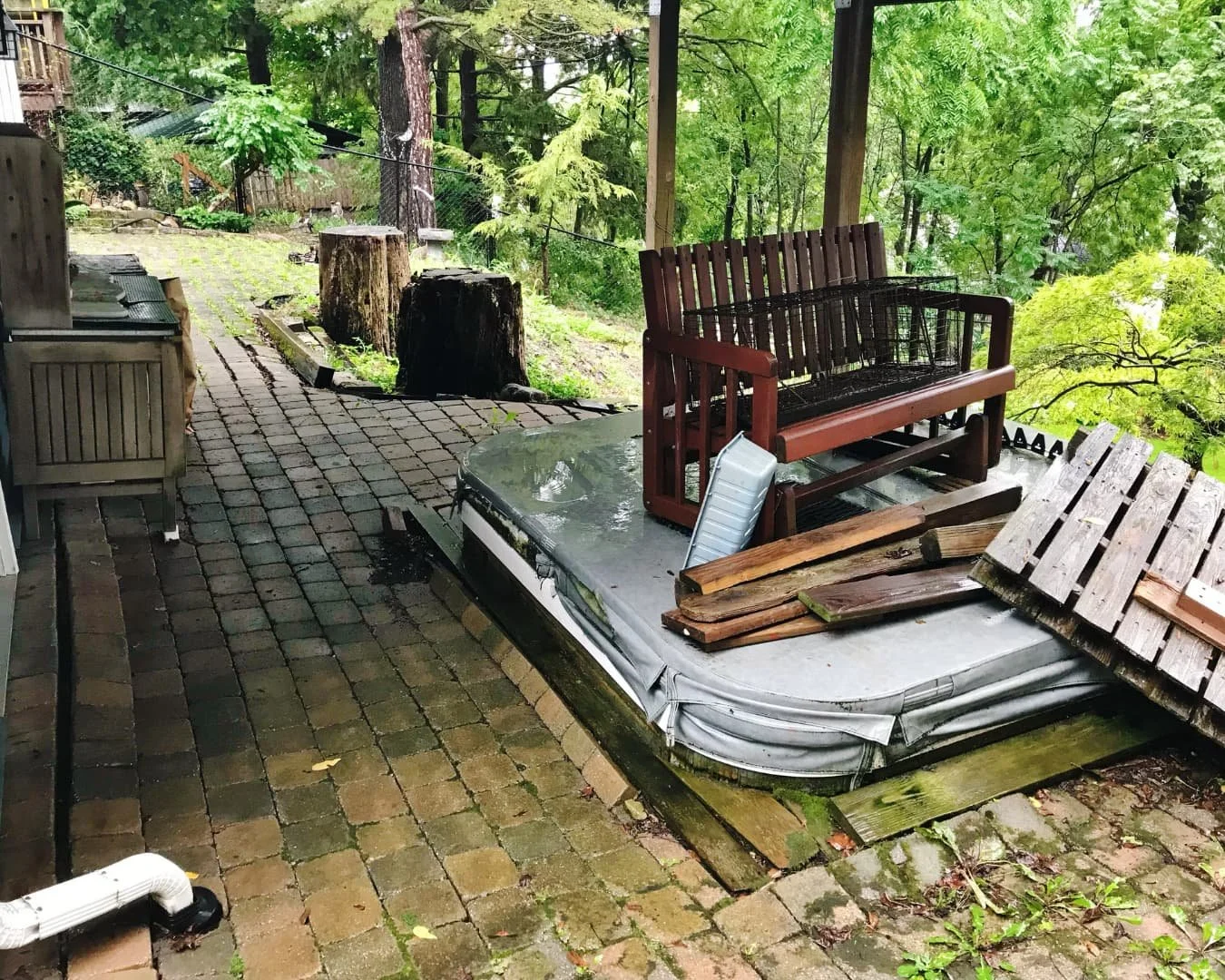 Existing backyard patio and landscape bed before hardscape improvements by Pines and Pavers in Central New York.