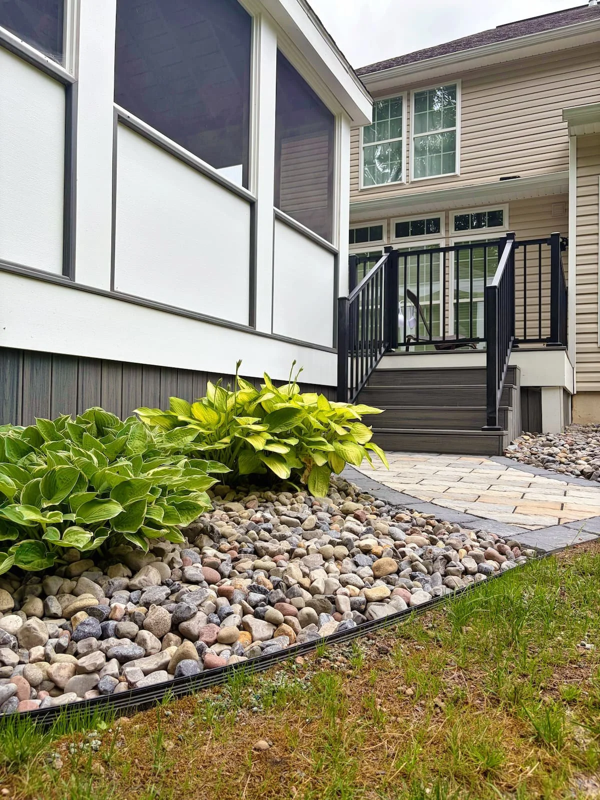 Custom paver patio with warm outdoor landscape lighting by Pines and Pavers in Central NY.