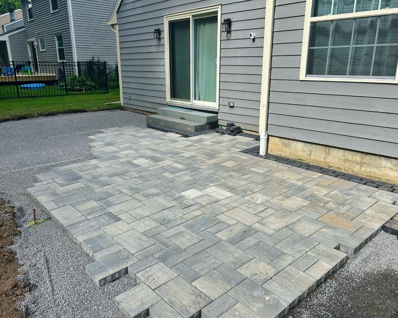 Completed backyard patio with seating by Pines and Pavers in Brewerton, New York.