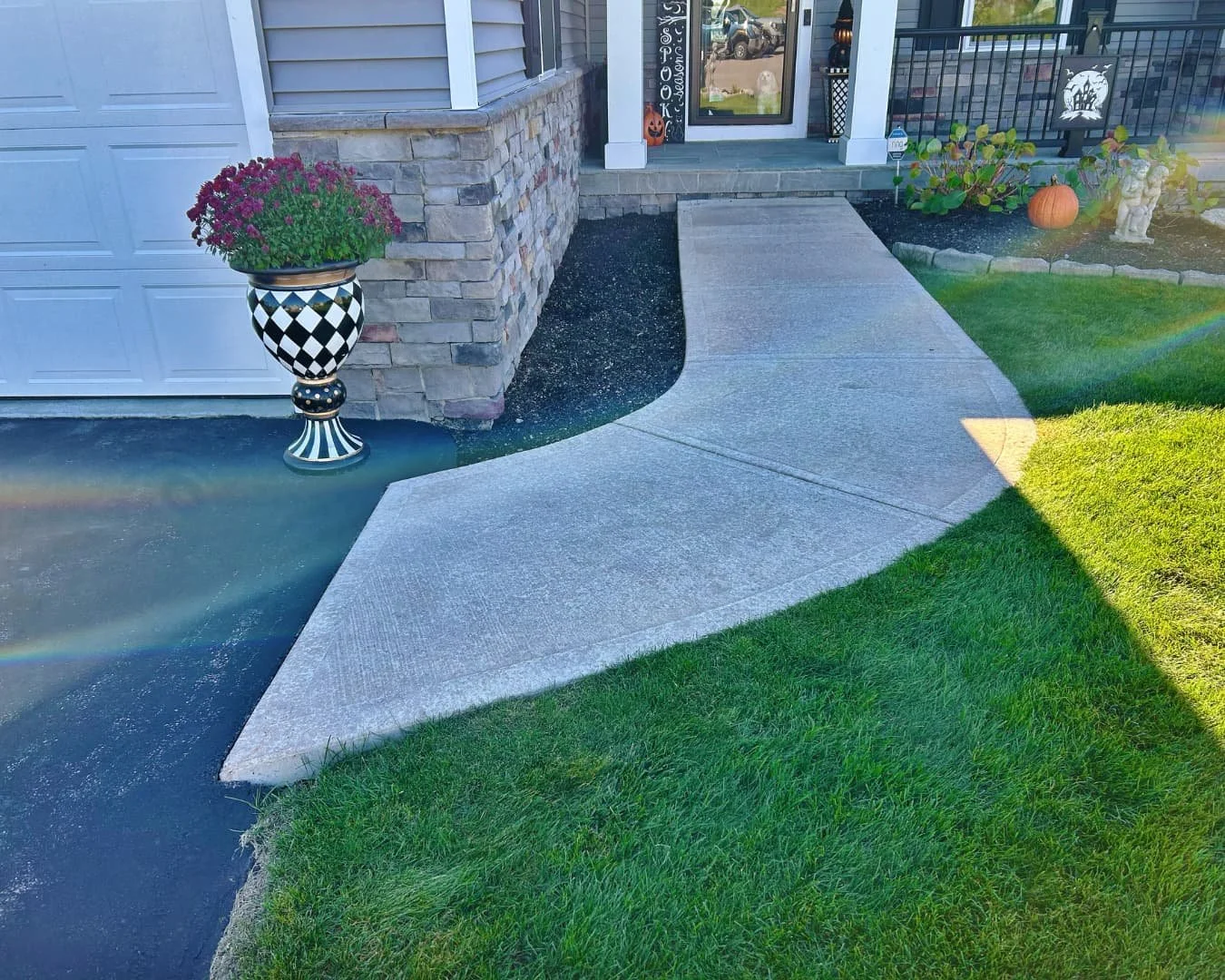     Front exterior of a home with a newly installed curved concrete walkway leading to the covered entry.