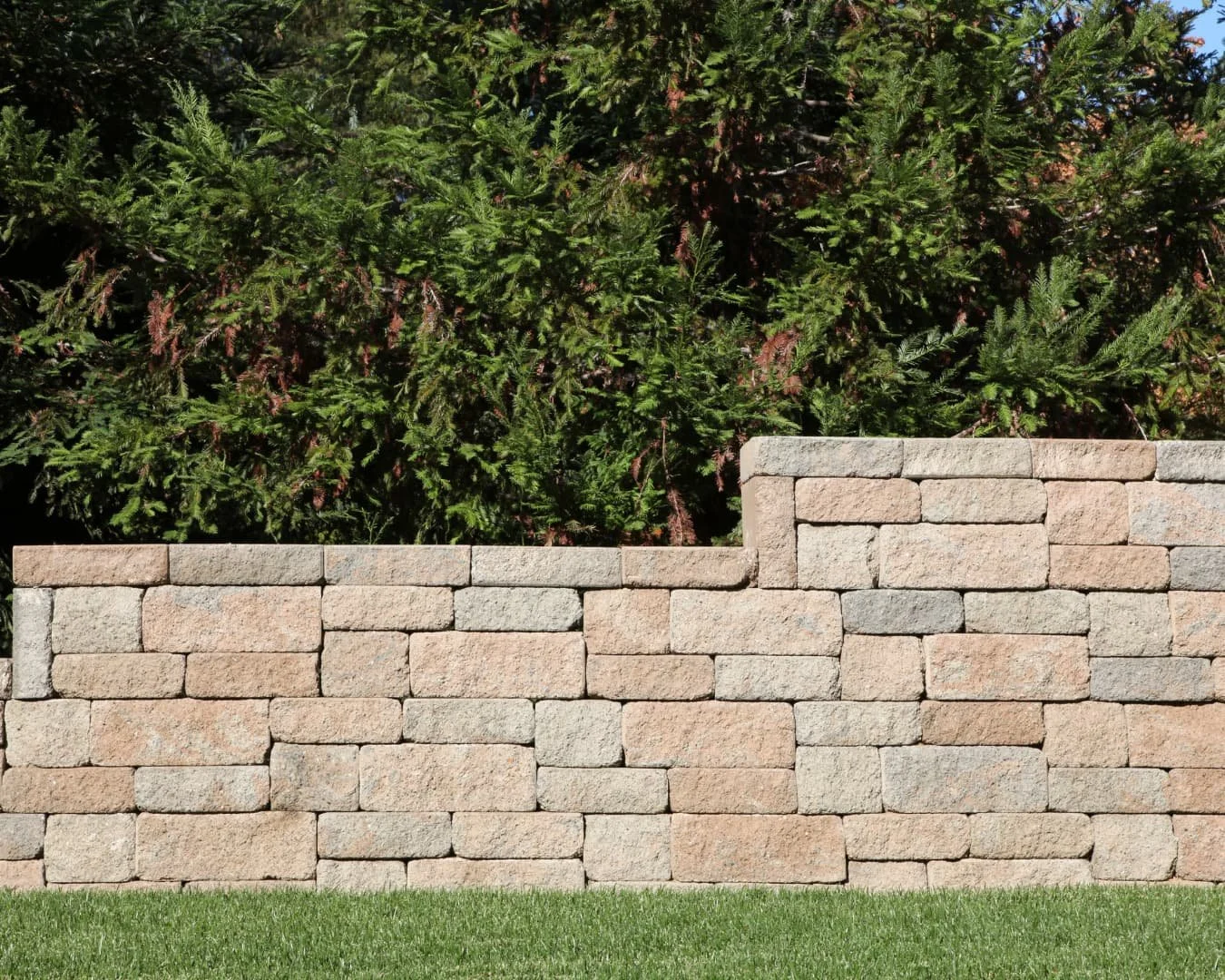 Tiered retaining wall inspiration featuring horizontal stone courses and structured grade changes.