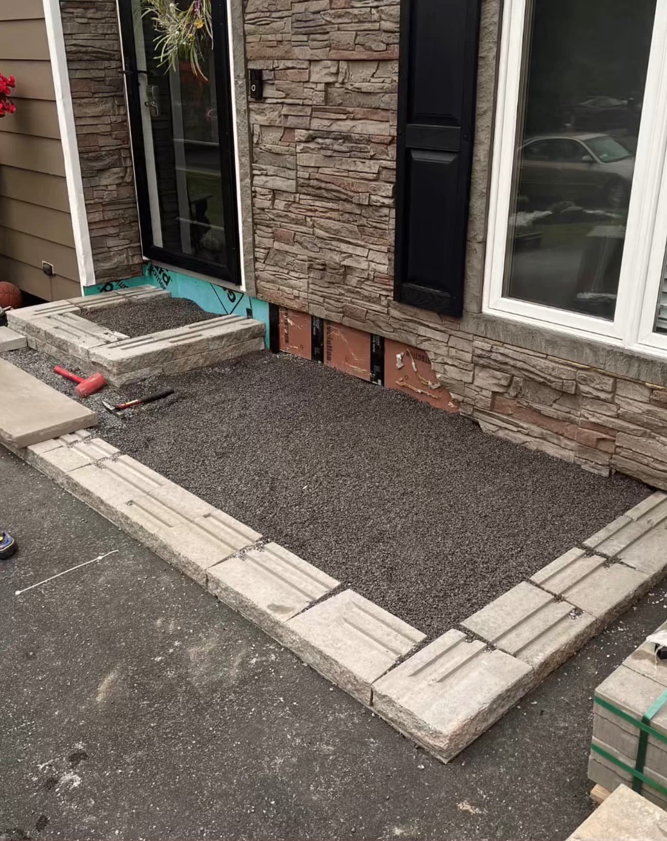 Front entry hardscape detail at an Upstate New York home with a paver landing and clean edge definition.