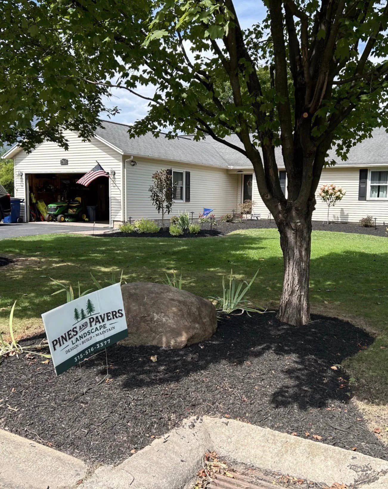 Backyard seating area landscaping at a Central New York home with decorative stone ground cover, patio furniture, and surrounding plantings. 