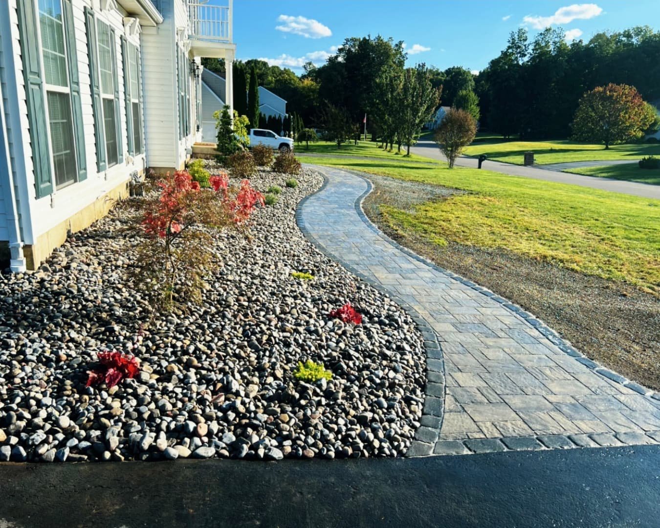 Front foundation landscaping at an Upstate New York home with trimmed shrubs, mulch beds, and fresh lawn.