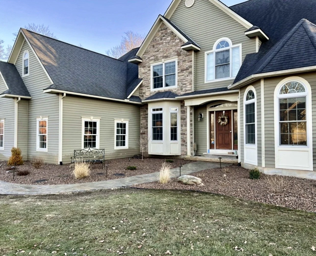 Front entry landscape bed at a Cazenovia, NY home with fresh mulch, stone edging, and a polished curb appeal update.