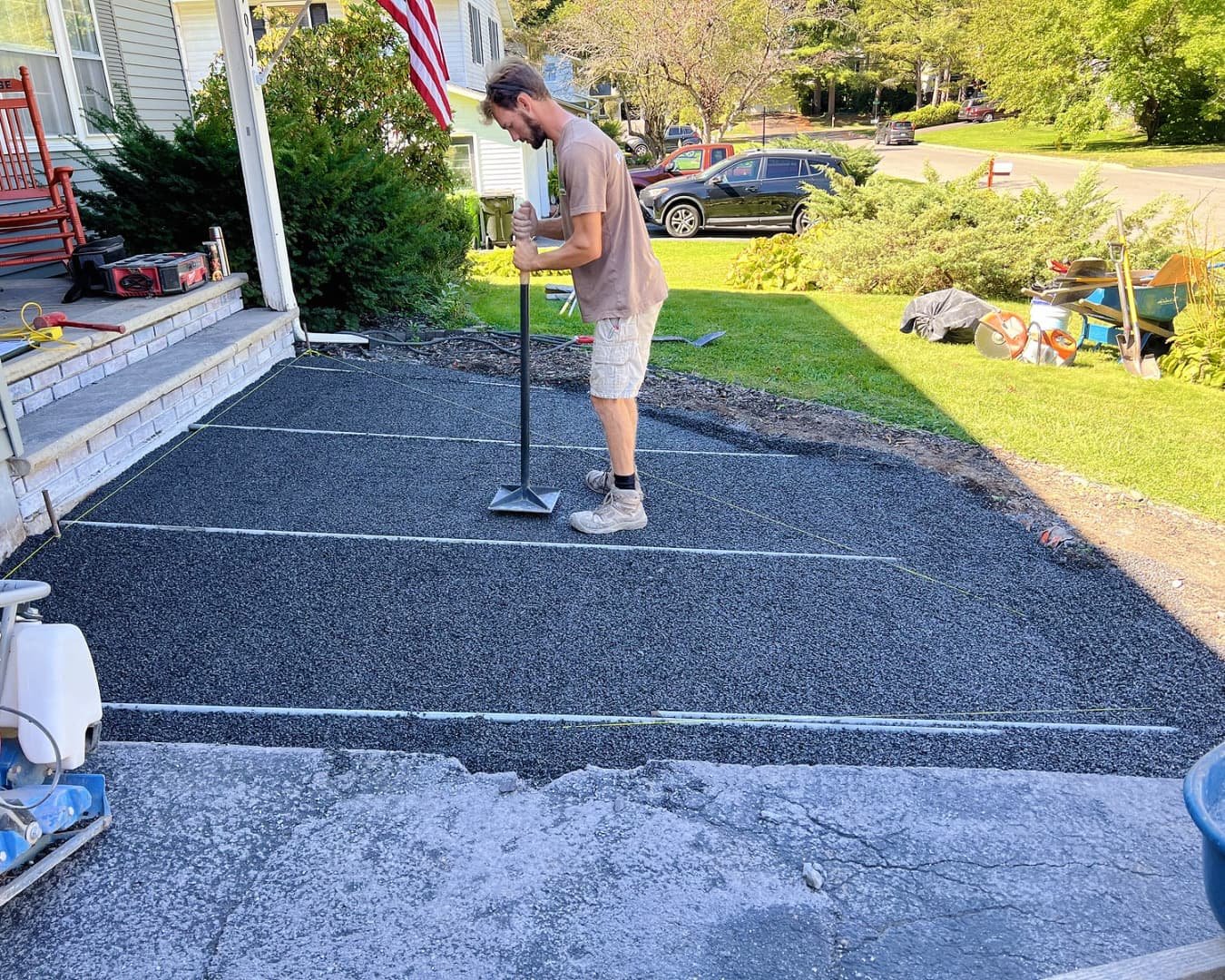 Front walkway and patio installation at a Manlius, NY home with clean grading, fresh lawn edge, and finished paver design.