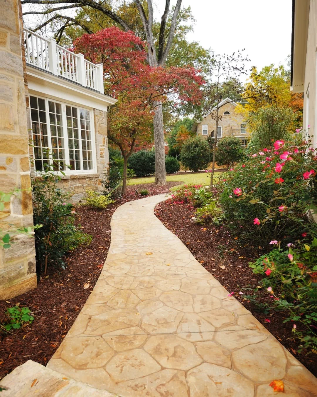 Walkway inspiration with a curved paver path bordered by lawn and natural stone edging.
