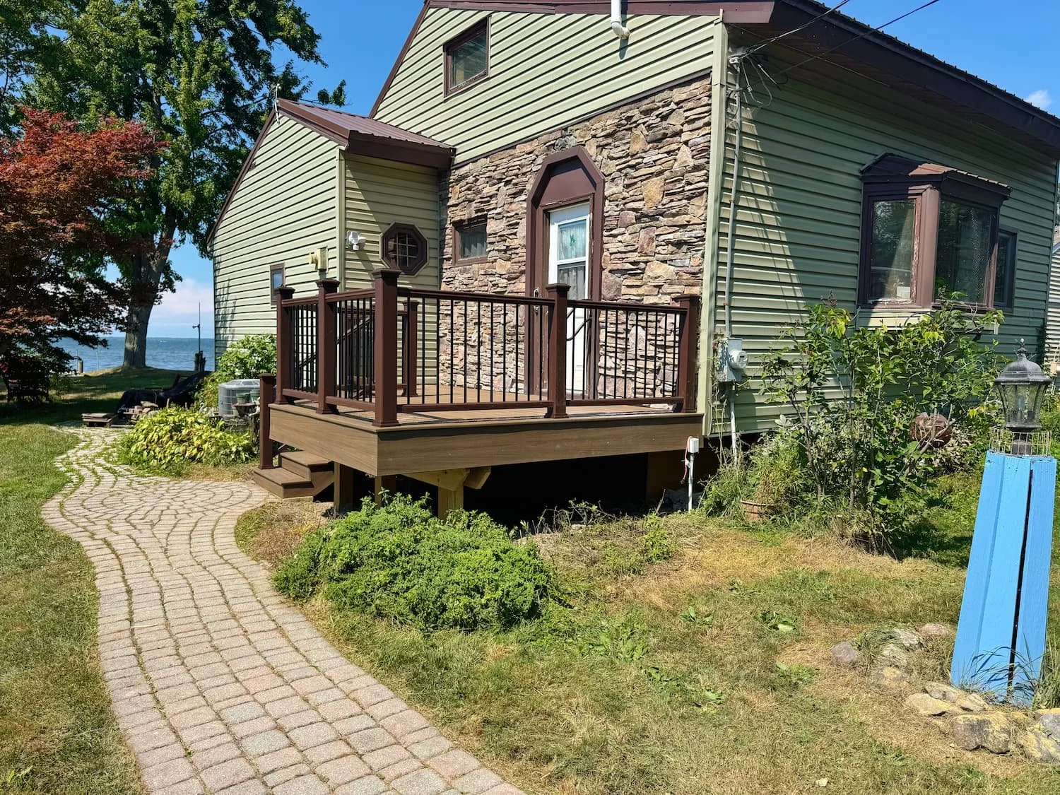 Raised composite deck with brown and black railing overlooking the yard in Central New York