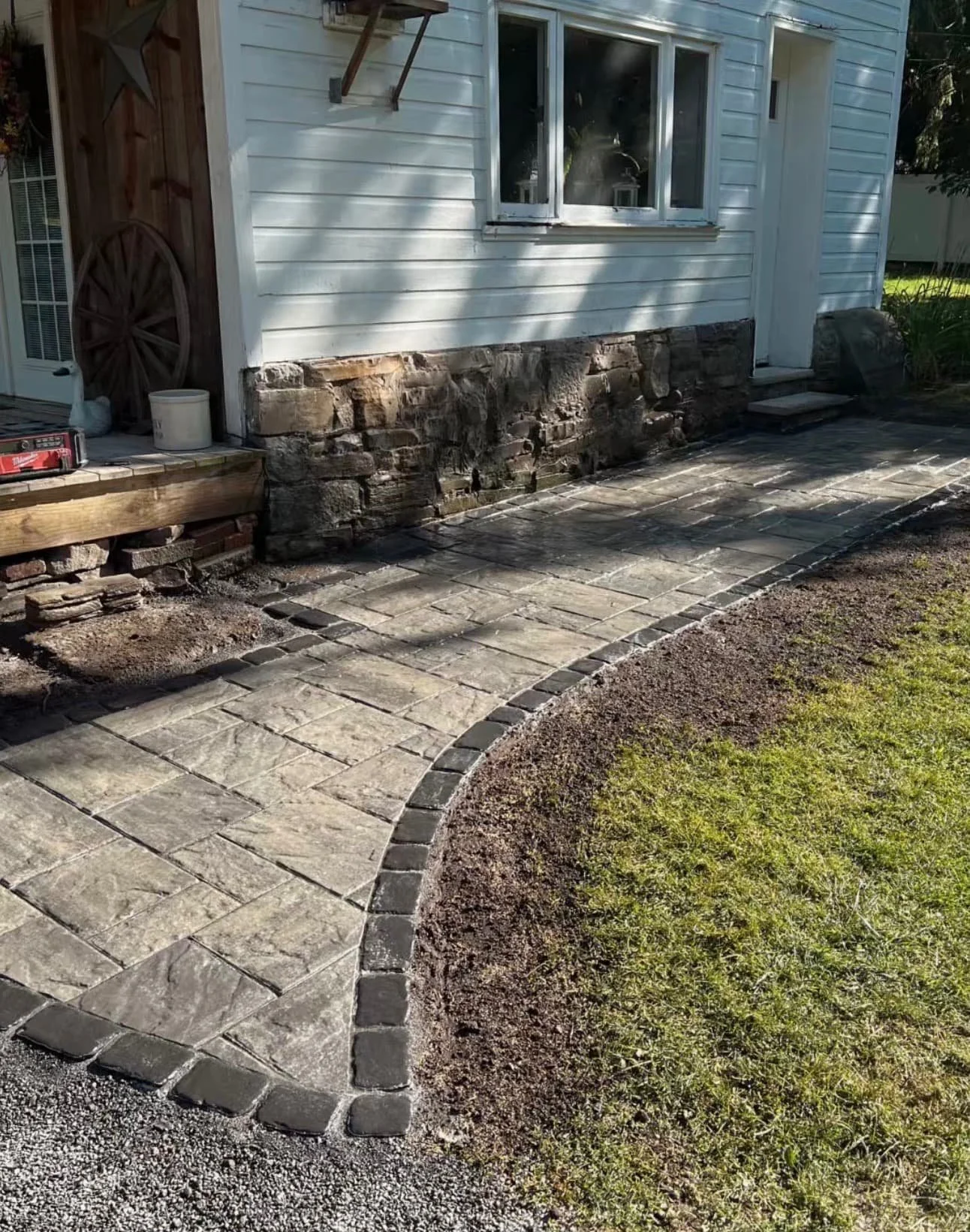 Side yard paver walkway at a Baldwinsville, NY home with a clean straight layout and fresh lawn edge.