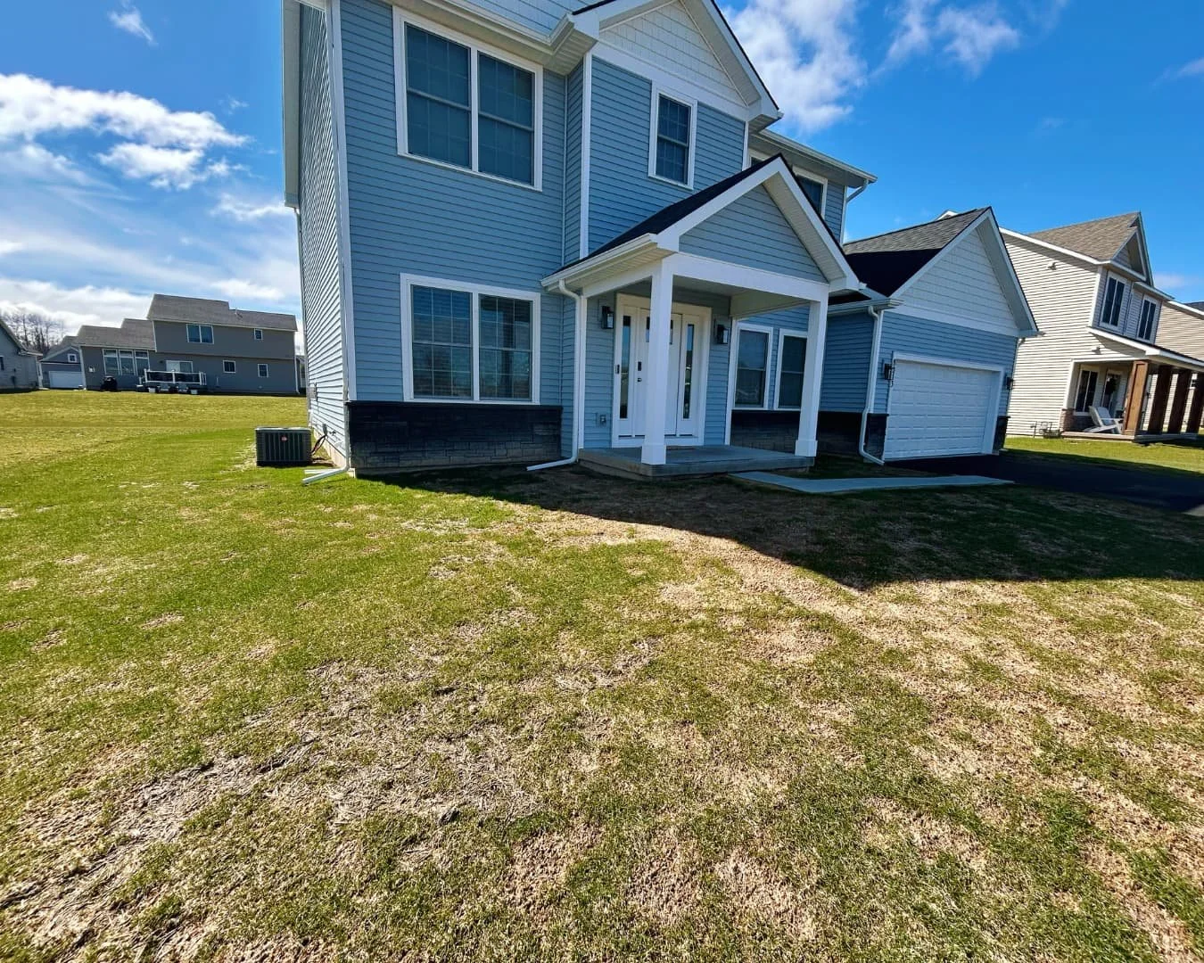     Home front entry before new sidewalk installation with grass lawn leading to the front door.