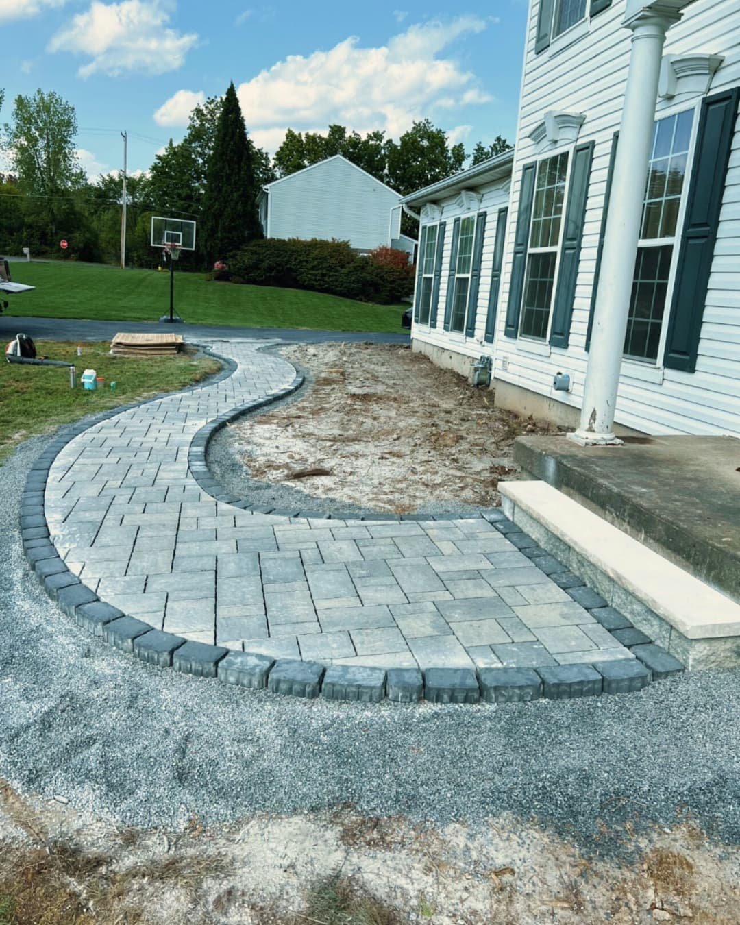 Front walkway and landscape bed design at a Skaneateles, NY property with fresh mulch and curved hardscape lines.