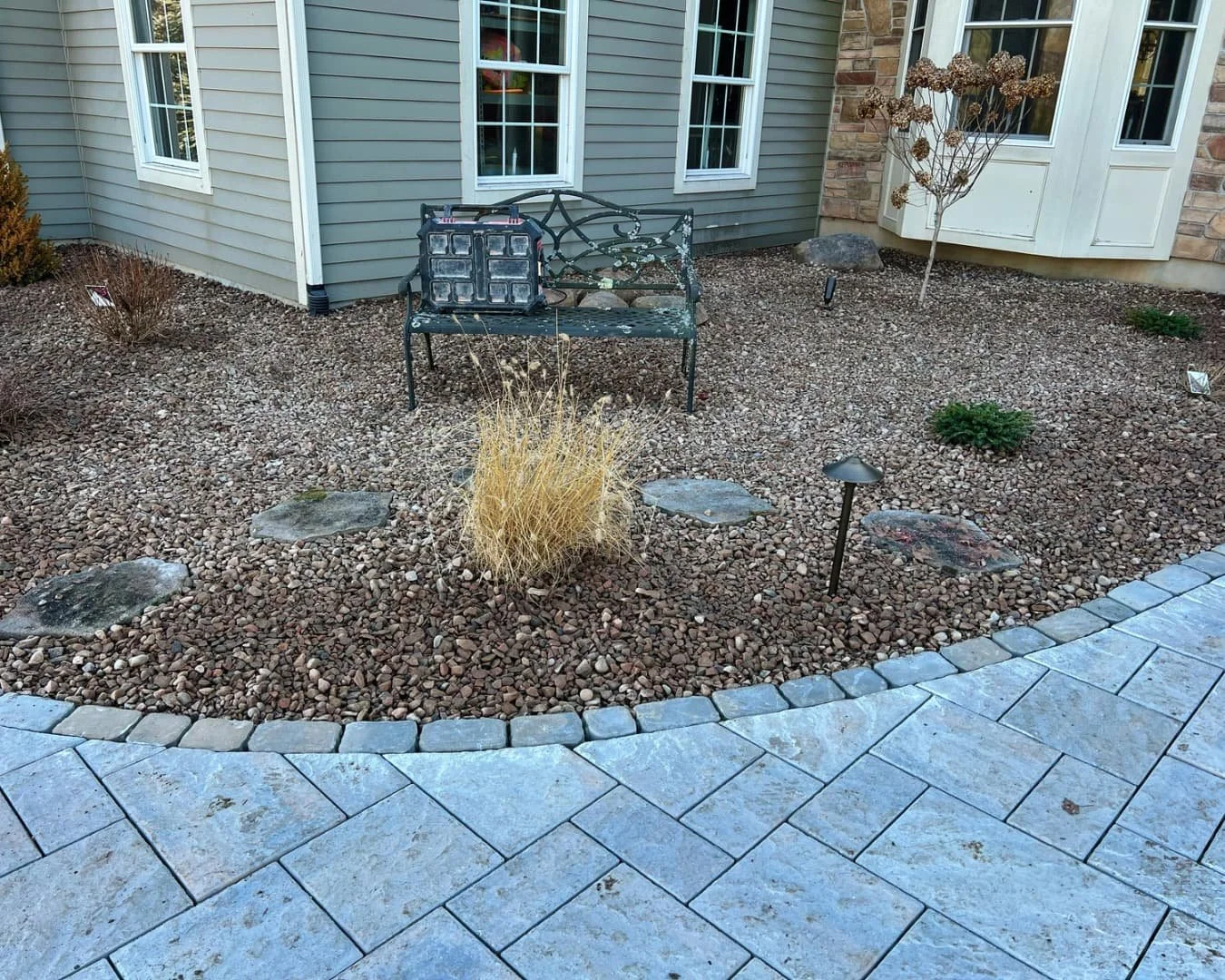 River rock bed and paver edge detail completed by Pines and Pavers in Fayetteville, New York.