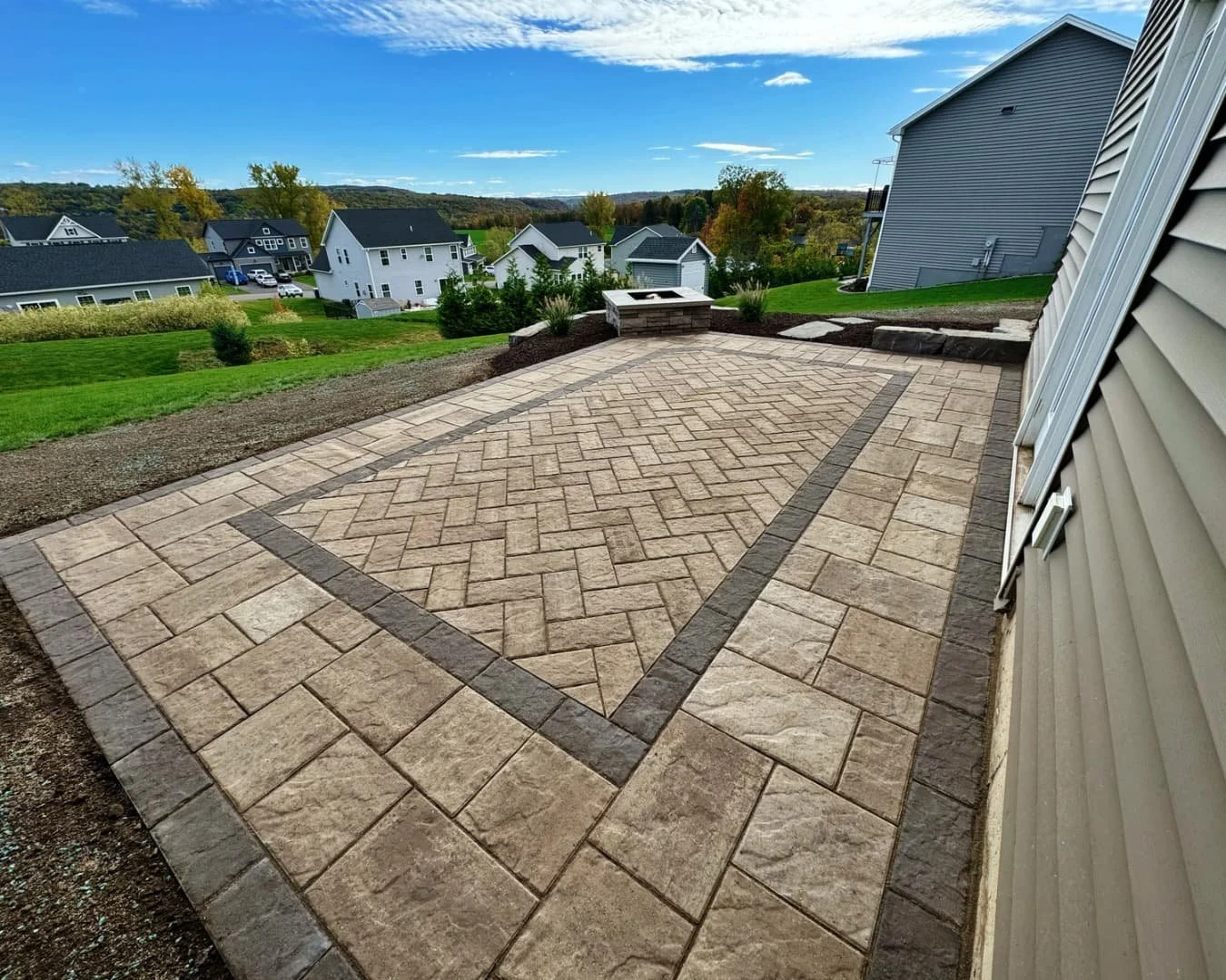 Raised patio and step wall overview completed by Pines and Pavers in Lysander, New York.