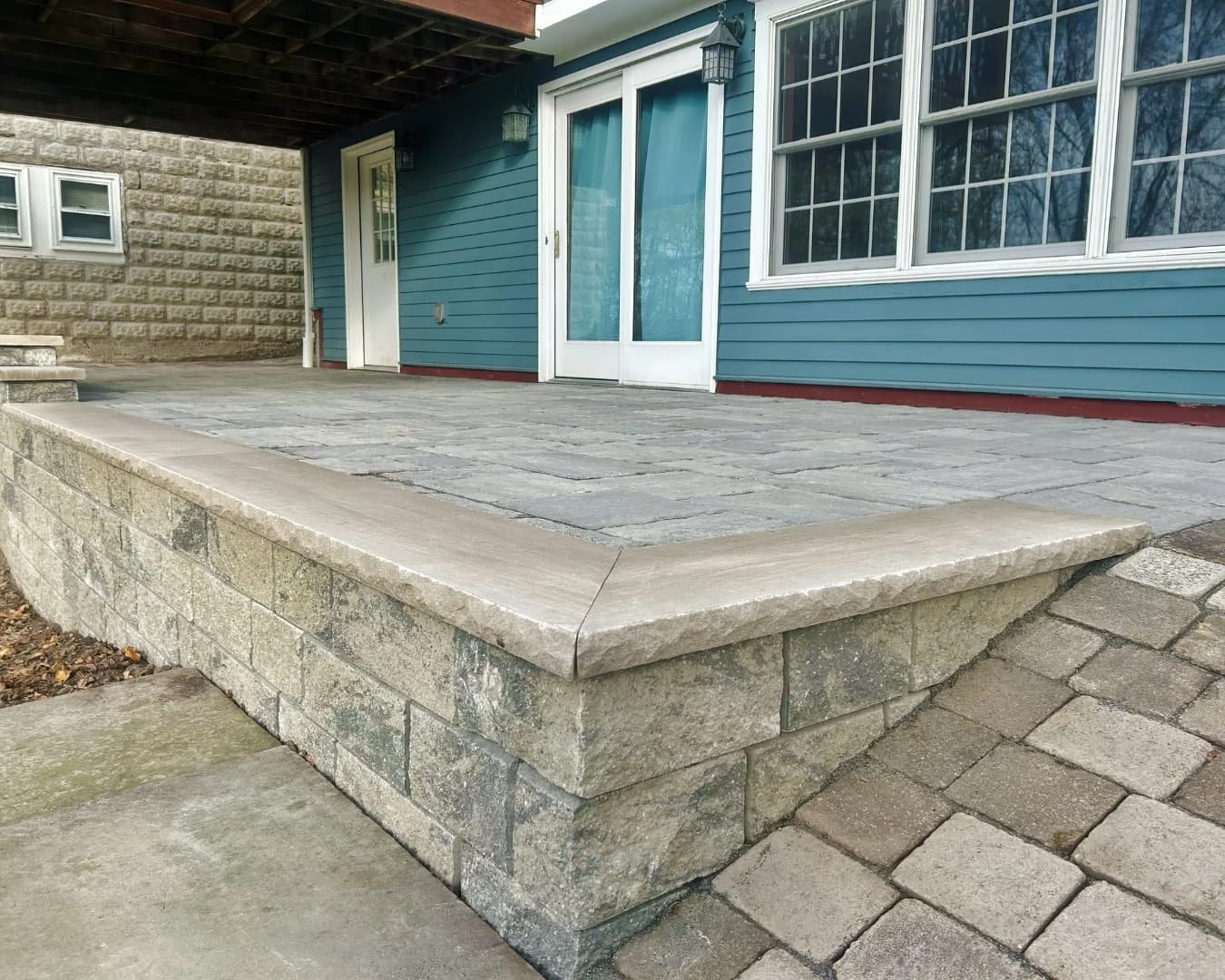 Raised paver patio with block wall detail completed by Pines and Pavers.