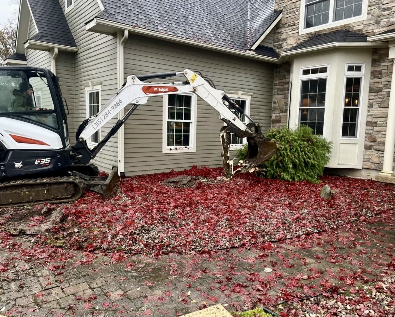 Rear yard grading and site preparation at a Central New York home before hardscape and landscaping improvements.