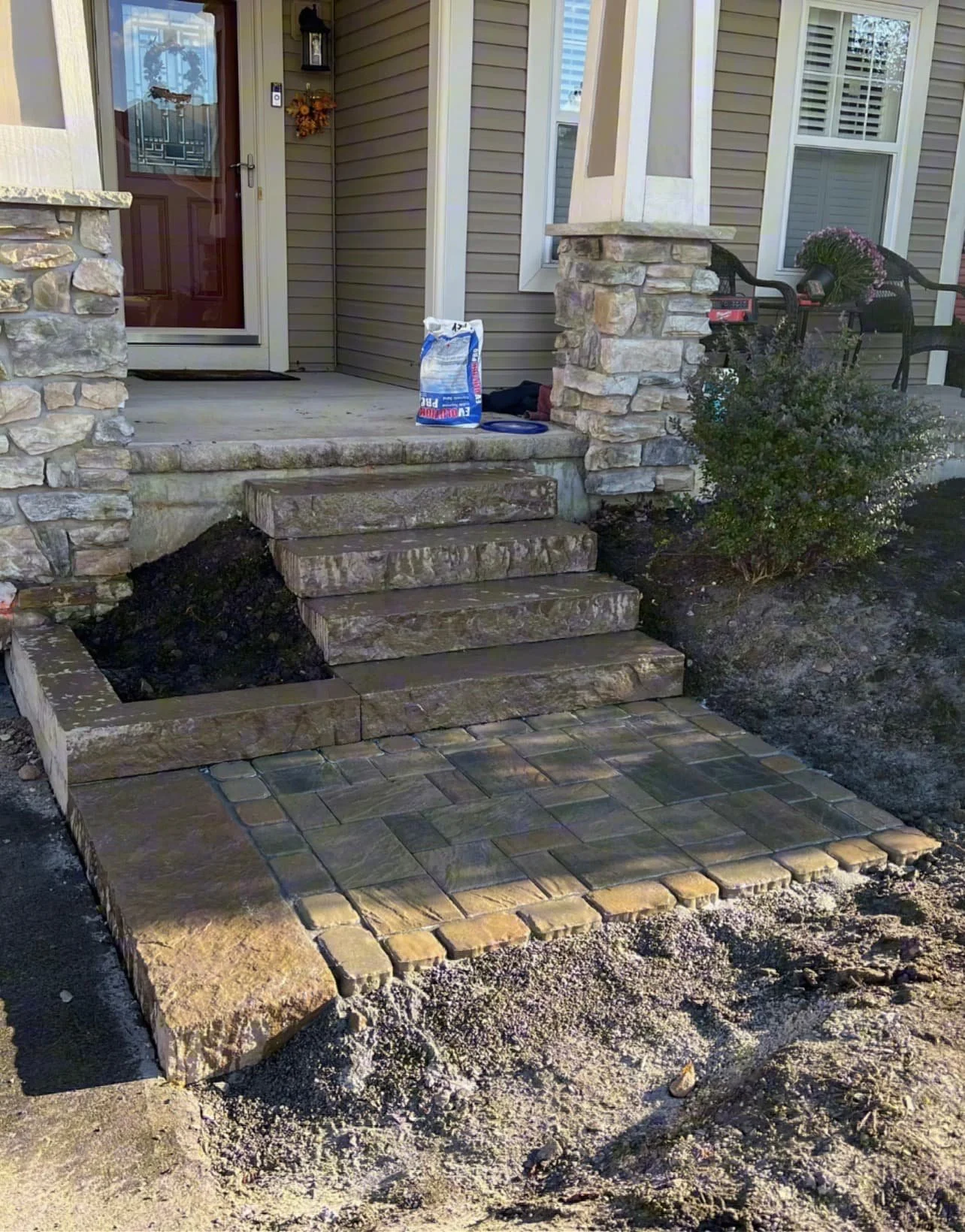 Stone front steps at a Central New York home with clean paver detailing and a newly finished entry.