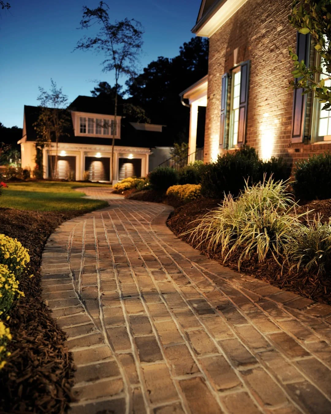 Walkway inspiration with a brick front entry path leading to the home through landscaped planting beds.