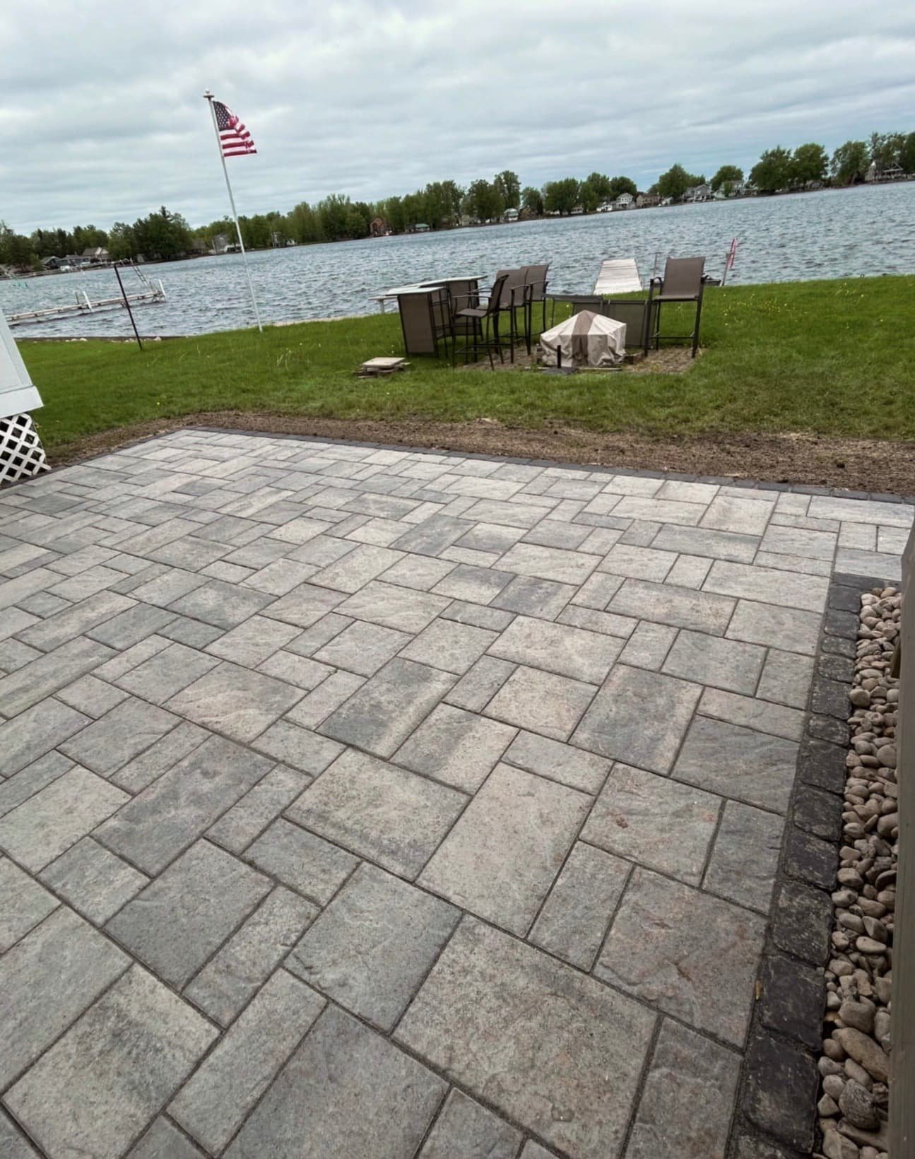 Rear view of a Baldwinsville, NY home with a newly installed paver patio and finished outdoor living space.