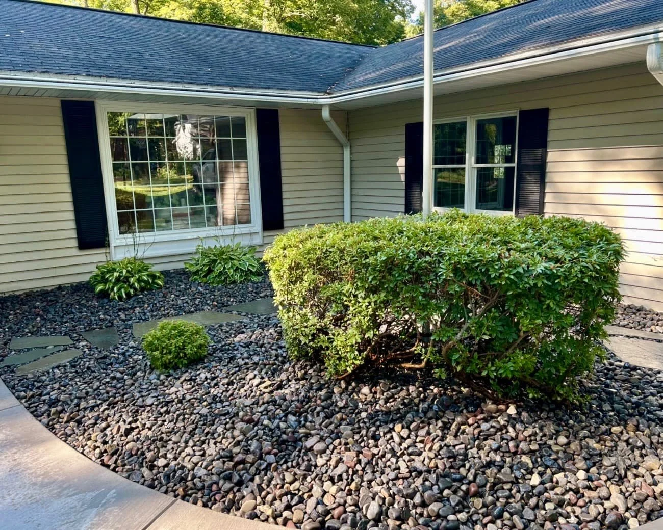 Front courtyard landscape design at an Upstate New York home with stone accents, mulch beds, and a clean finished look.
