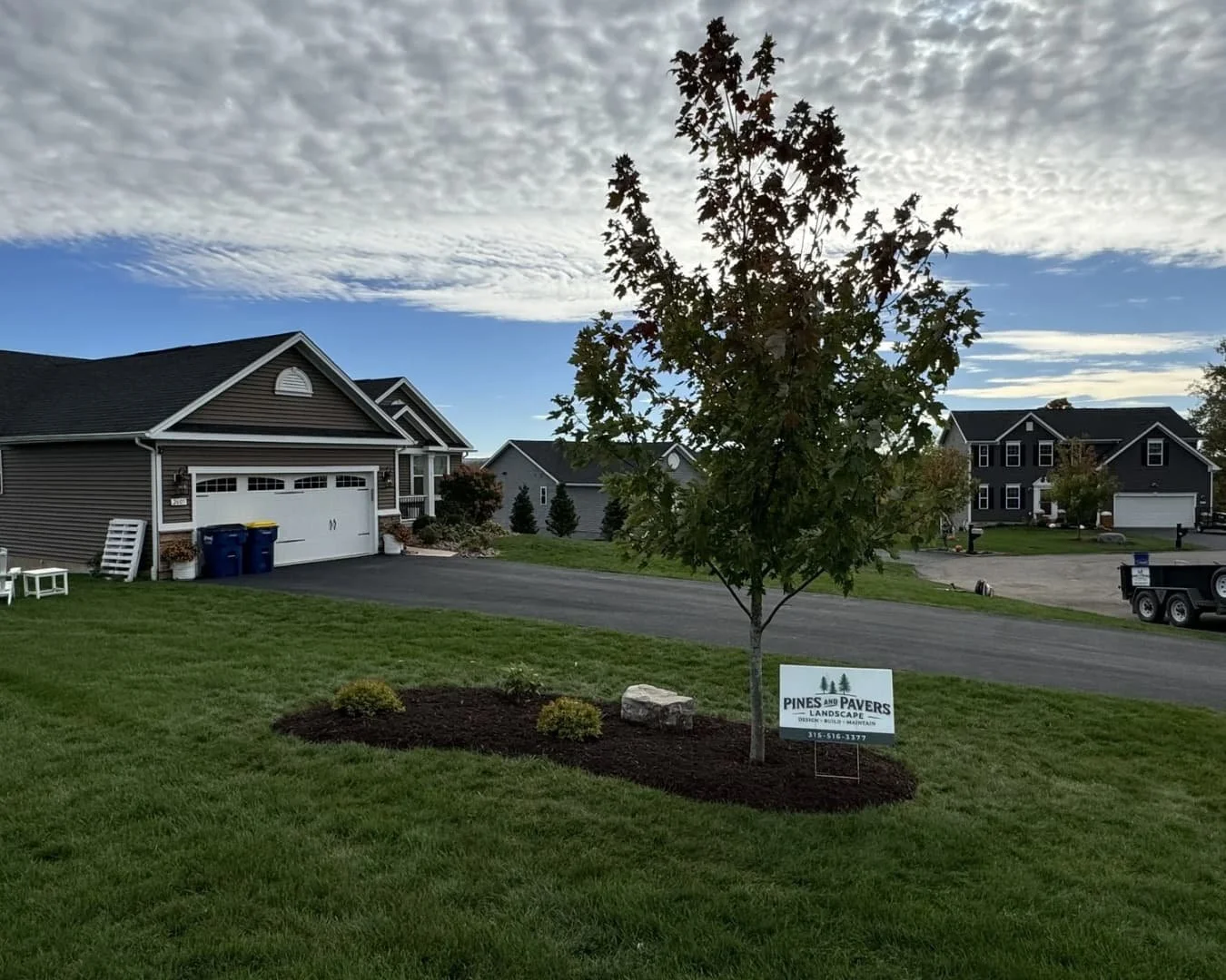 Rear elevation of a home with raised deck and stone hardscape work at a Baldwinsville, NY property.