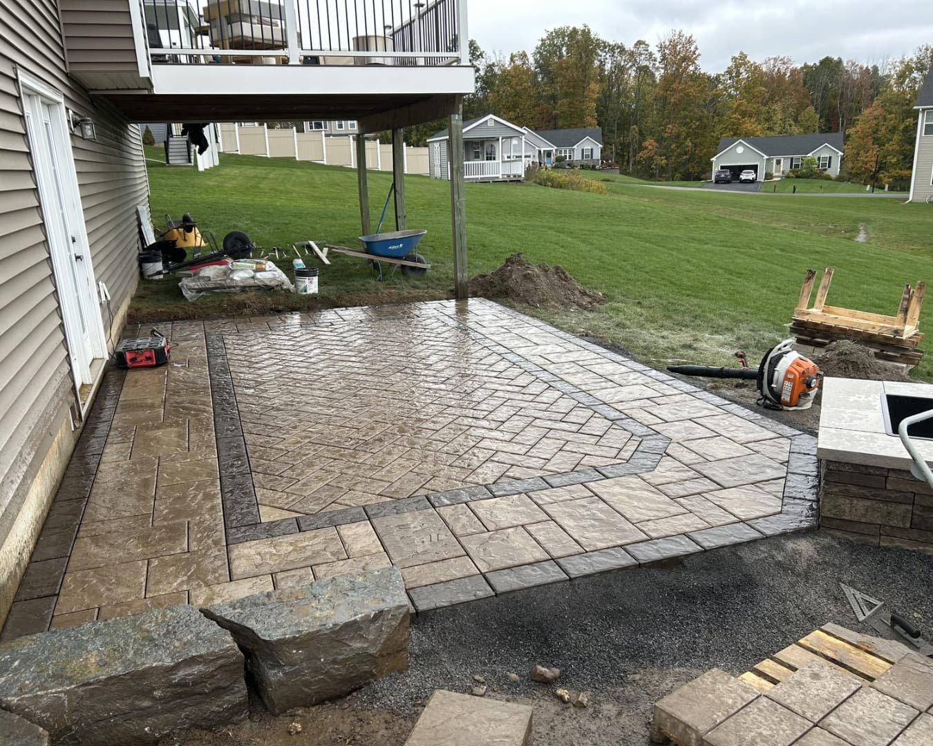 Curved paver walkway beside a home at an Upstate New York hardscape installation.