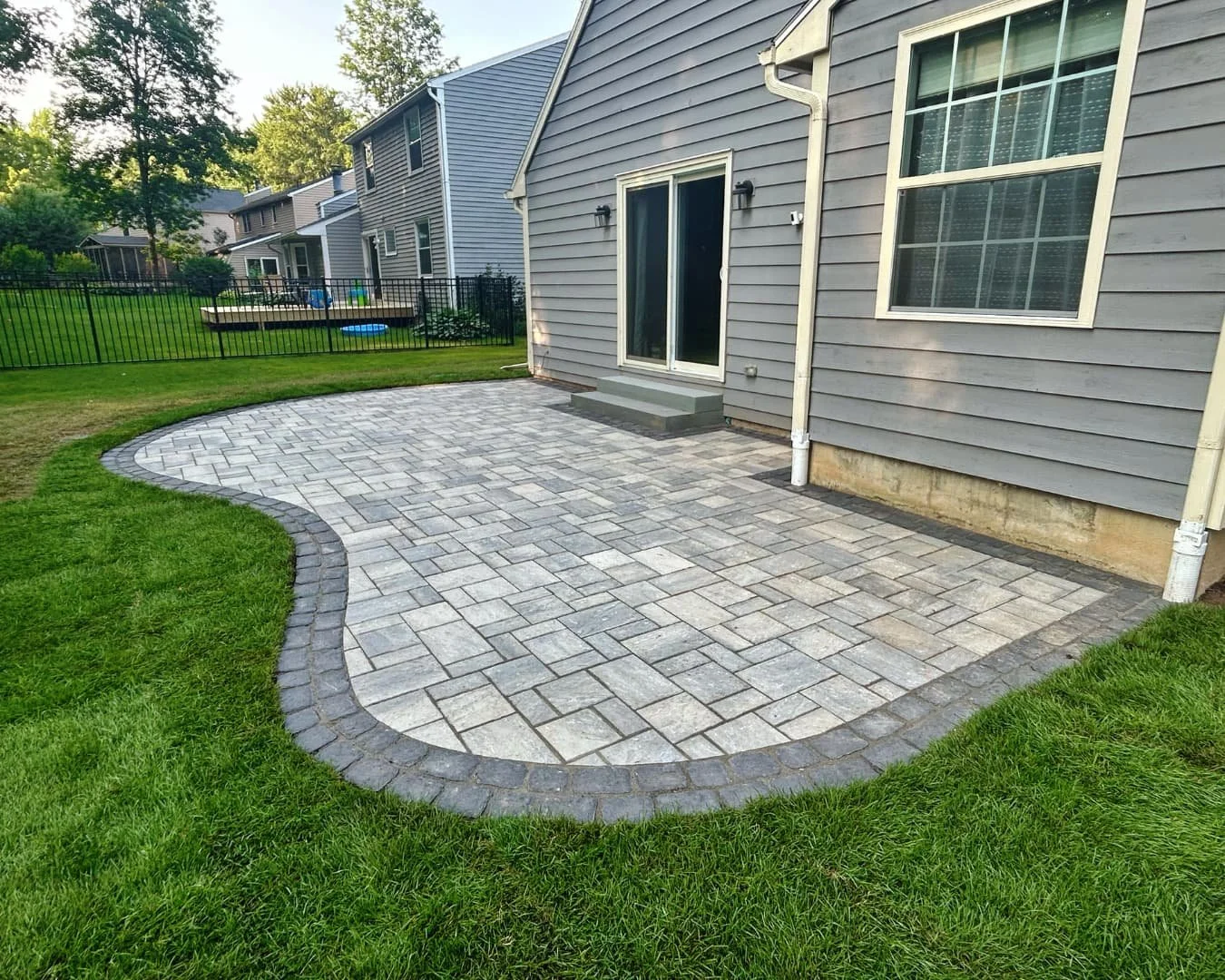 Curved patio shape and lawn border completed by Pines and Pavers in Baldwinsville, New York.