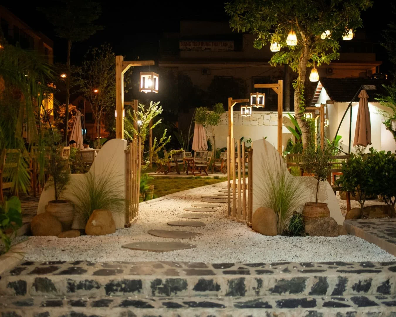 Outdoor lighting inspiration with a modern path light beside a walkway and layered landscape planting.