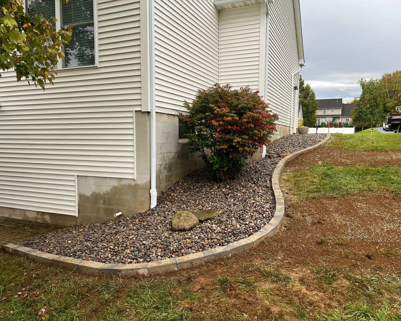 Curved foundation landscape bed completed by Pines and Pavers in Lysander, New York.