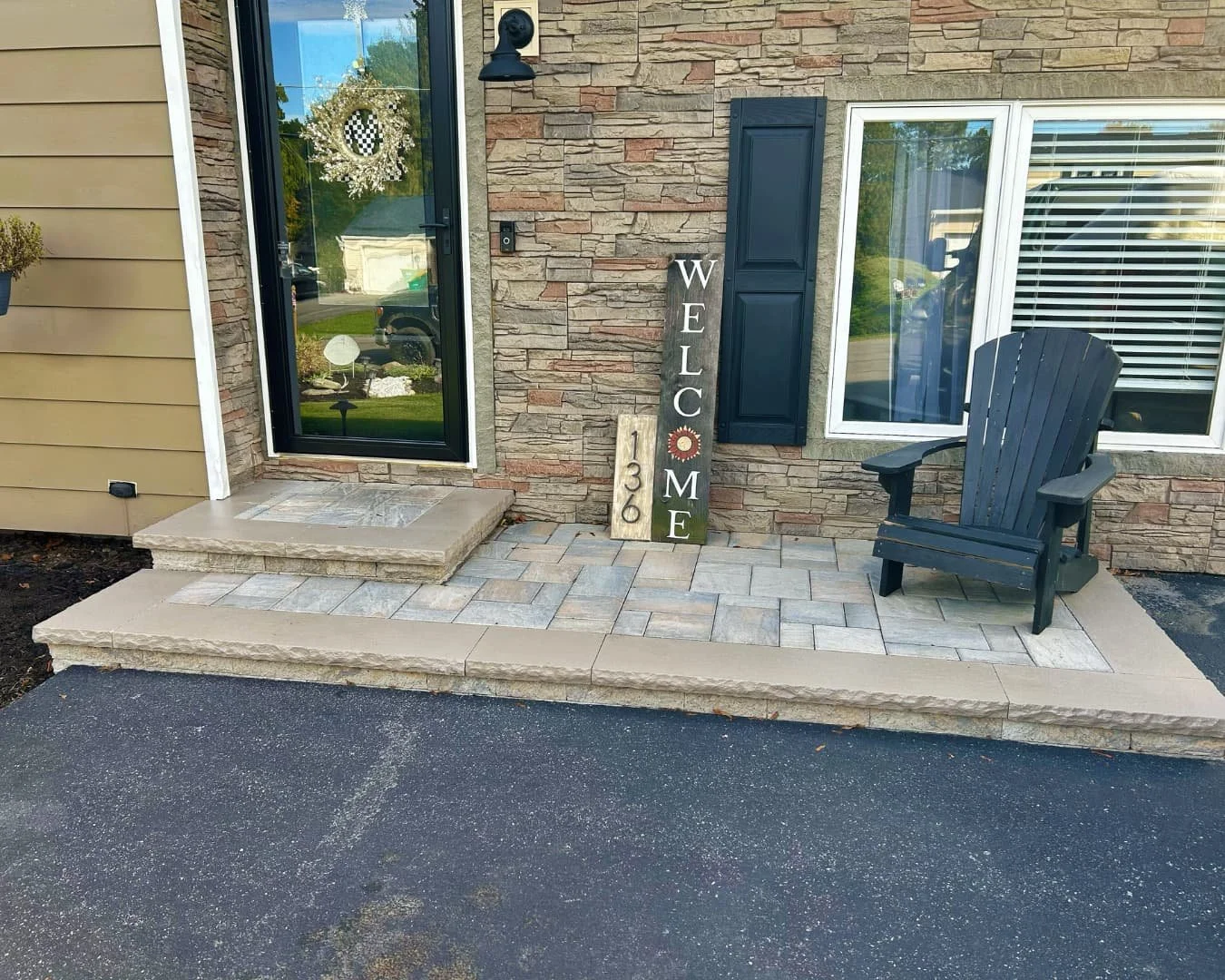 Entry paver patio detail with chair completed by Pines and Pavers in Camillus, New York.