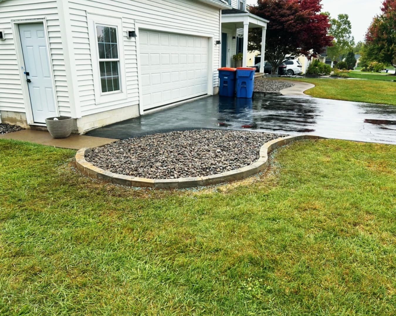 Curved front mulch bed at a Central New York home with clean edging and a polished foundation landscape.