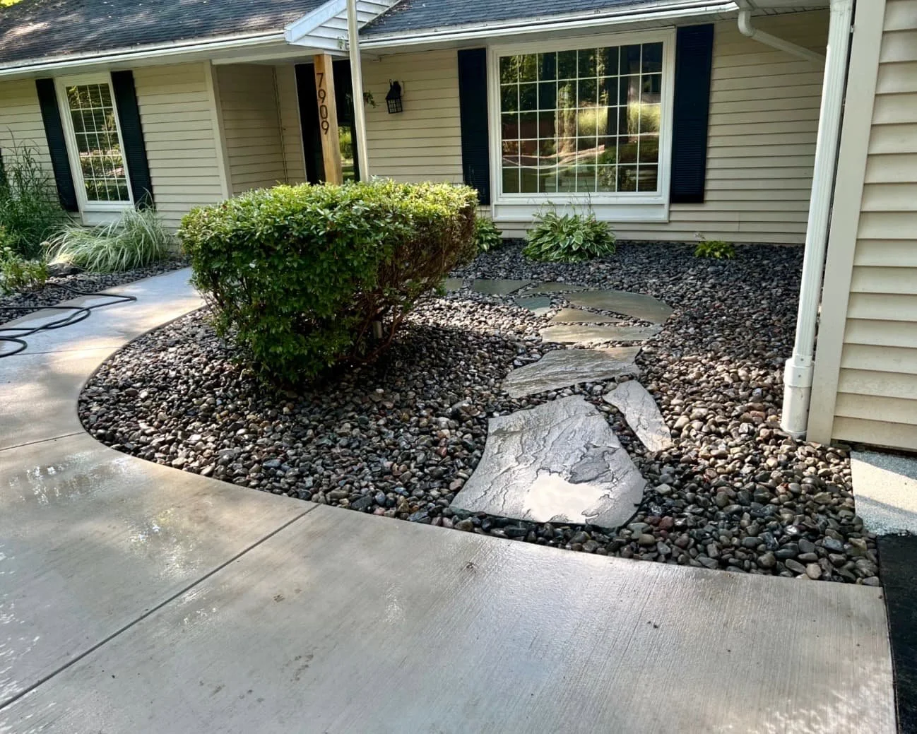 Front foundation landscaping at a Central New York home with fresh mulch, stone accents, and neatly shaped planting beds.