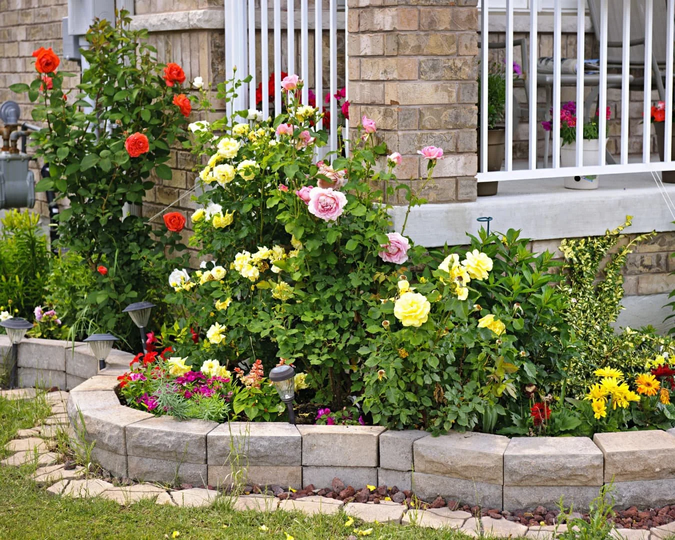 Raised garden bed inspiration featuring a curved flower bed with layered seasonal planting.