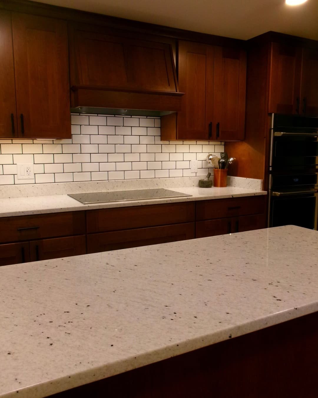 Kitchen island remodel in Central New York with granite countertops, wood floors, and updated cabinetry.