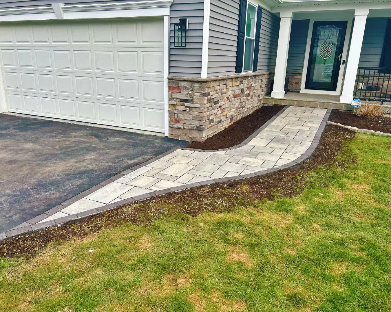     Residential front walkway connecting driveway and entry with paver surface and new planting beds.